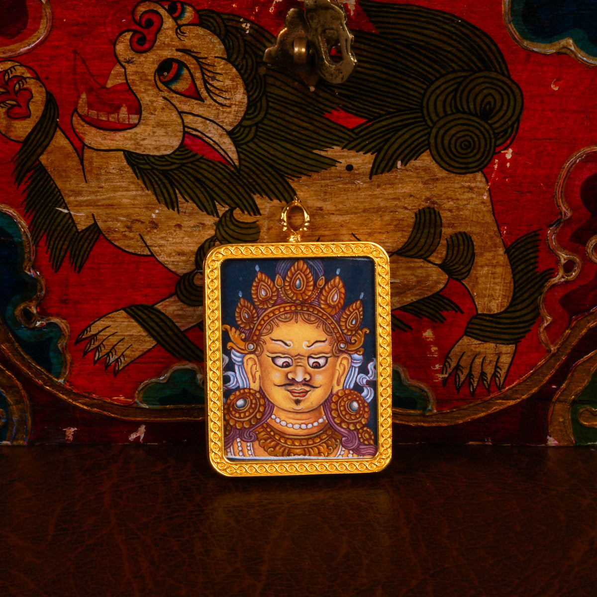 Yellow Zambhala Ghau pendant in a decorative gold-tone frame featuring a miniature Tibetan Buddhist wealth deity artwork handcrafted in Nepal.