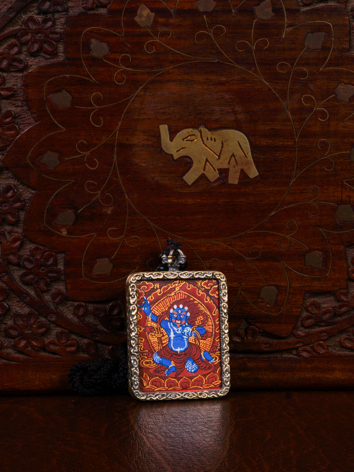 Khadgapani (Black Manjushree) Ghau pendant featuring a miniature Tibetan Buddhist wisdom protector artwork in a traditional metal frame handcrafted in Nepal.