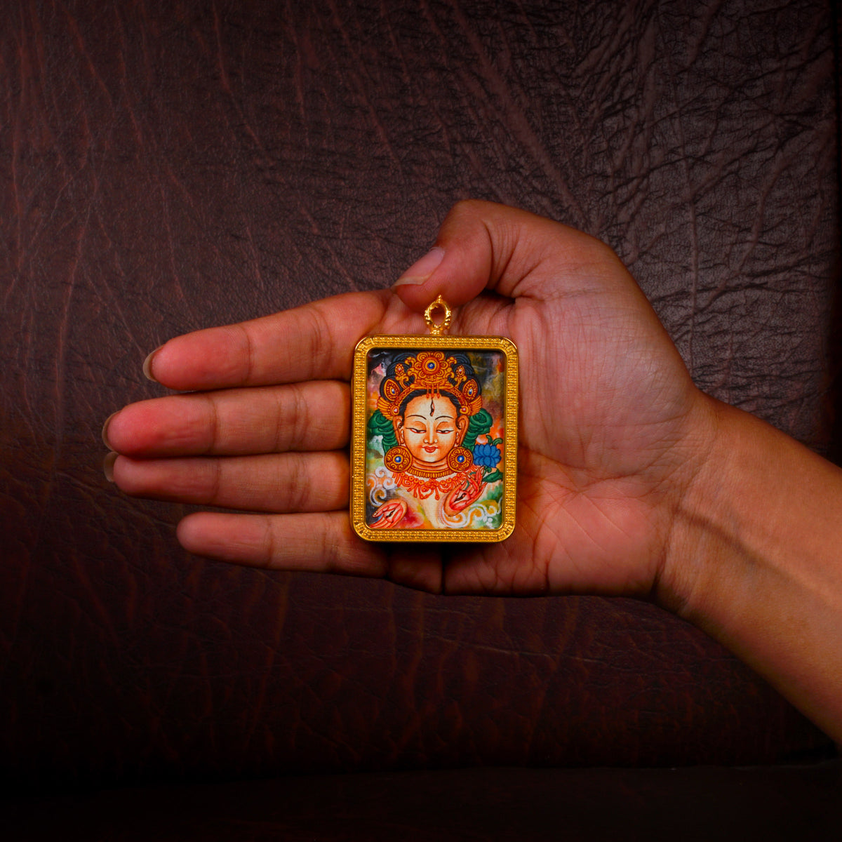 Newari White Tara Ghau pendant featuring a miniature Tibetan Buddhist goddess artwork in a decorative gold-tone frame handcrafted in Nepal.