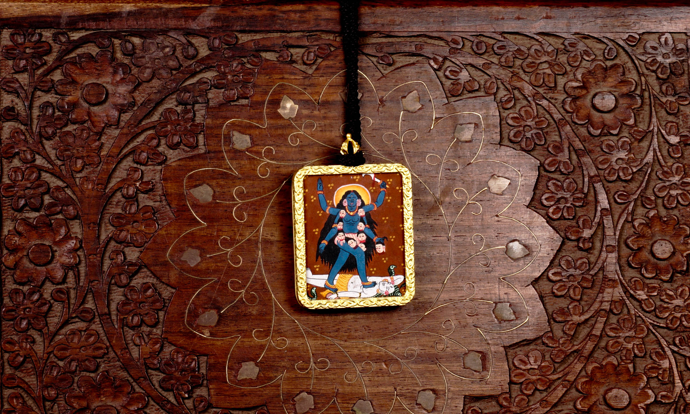 Hand-painted Goddess Kali miniature Thangka pendant in gold-accented copper Ghau locket with black beaded cord.