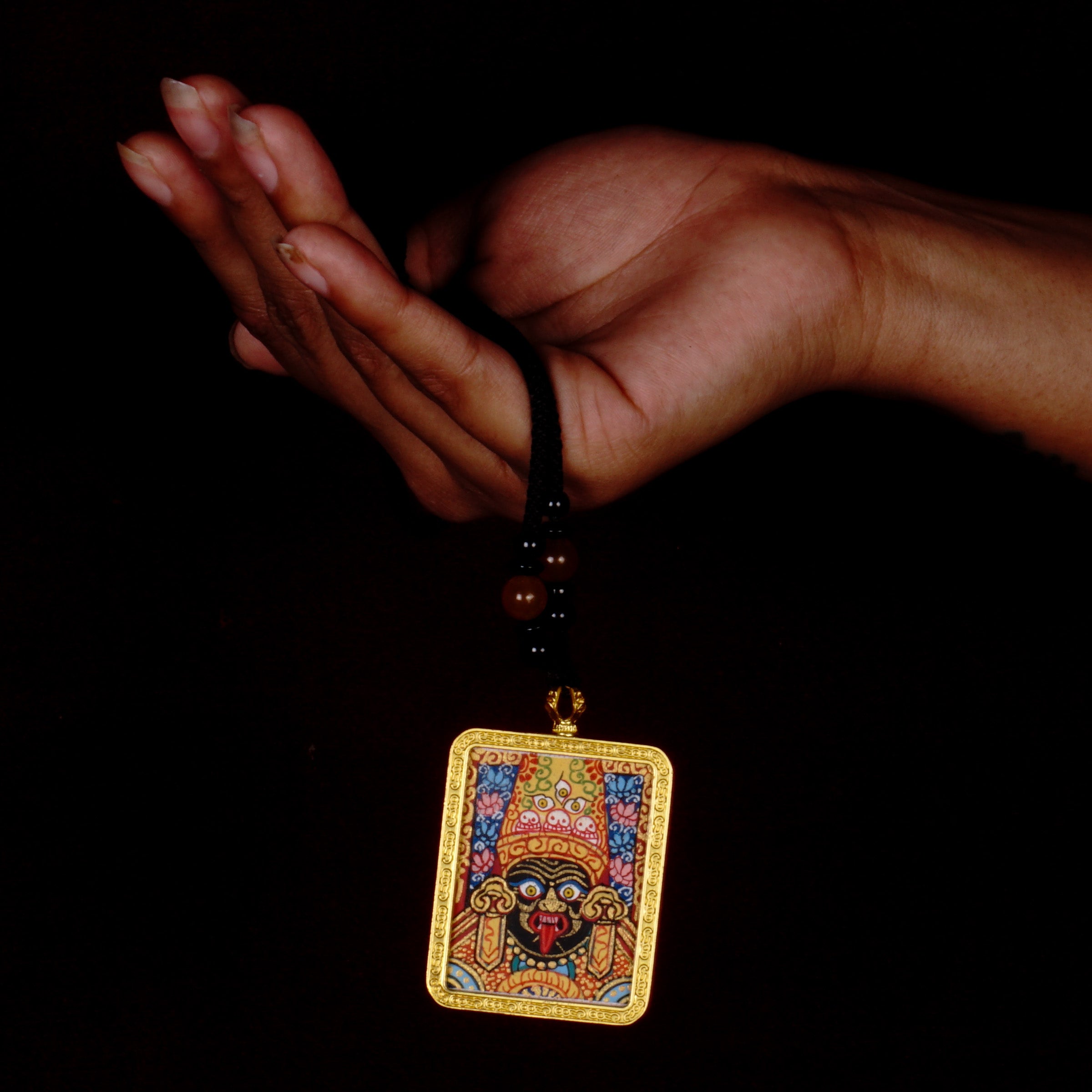 Hand-painted Goddess Kali miniature Thangka pendant in gold-accented copper Ghau locket with black beaded cord.