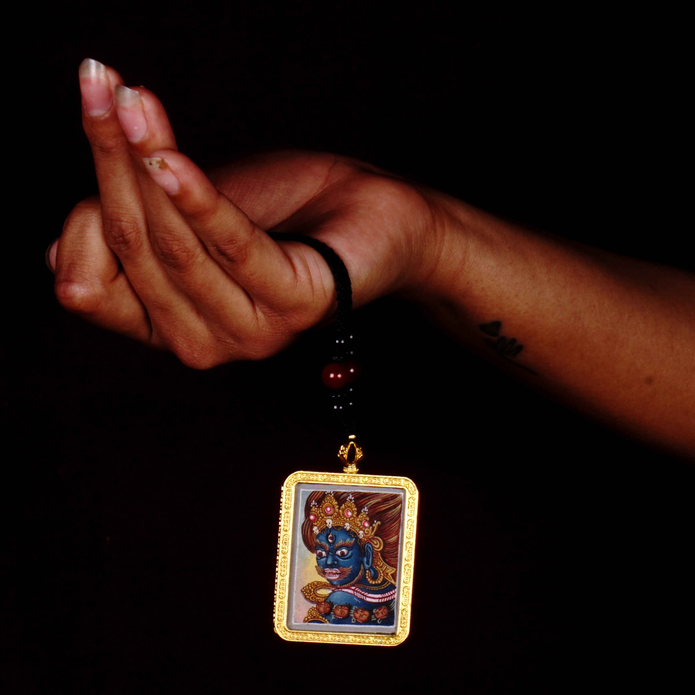 Hand-painted Mahakala miniature Thangka pendant in gold-accented copper Ghau locket with black beaded cord.