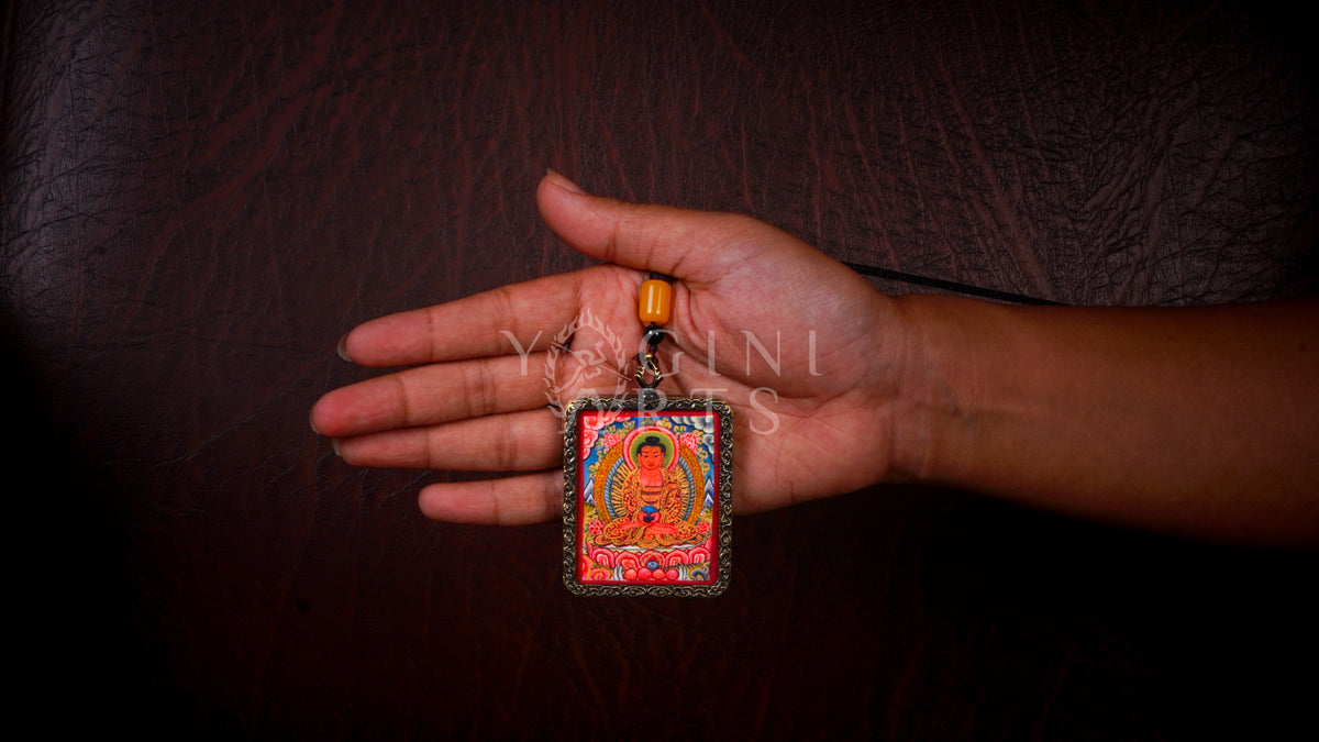 Hand-painted Amitabha Buddha Ghau pendant in an antique silver-tone frame, handcrafted in Nepal using traditional Himalayan miniature painting techniques.