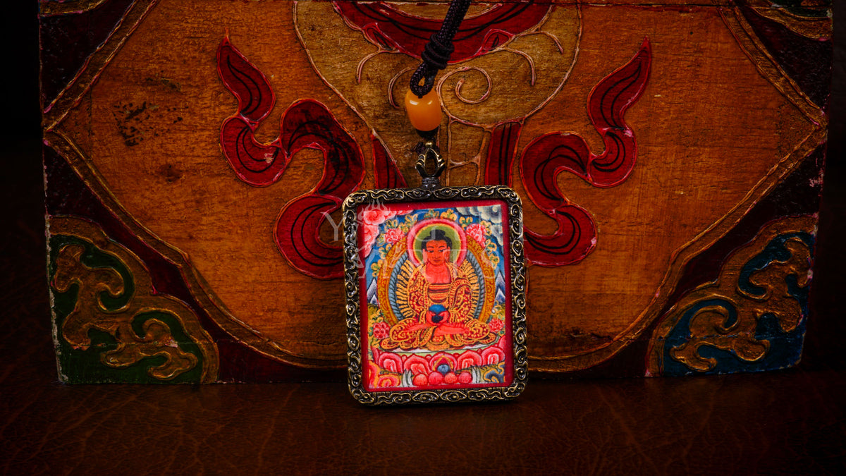 Hand-painted Amitabha Buddha Ghau pendant in an antique silver-tone frame, handcrafted in Nepal using traditional Himalayan miniature painting techniques.