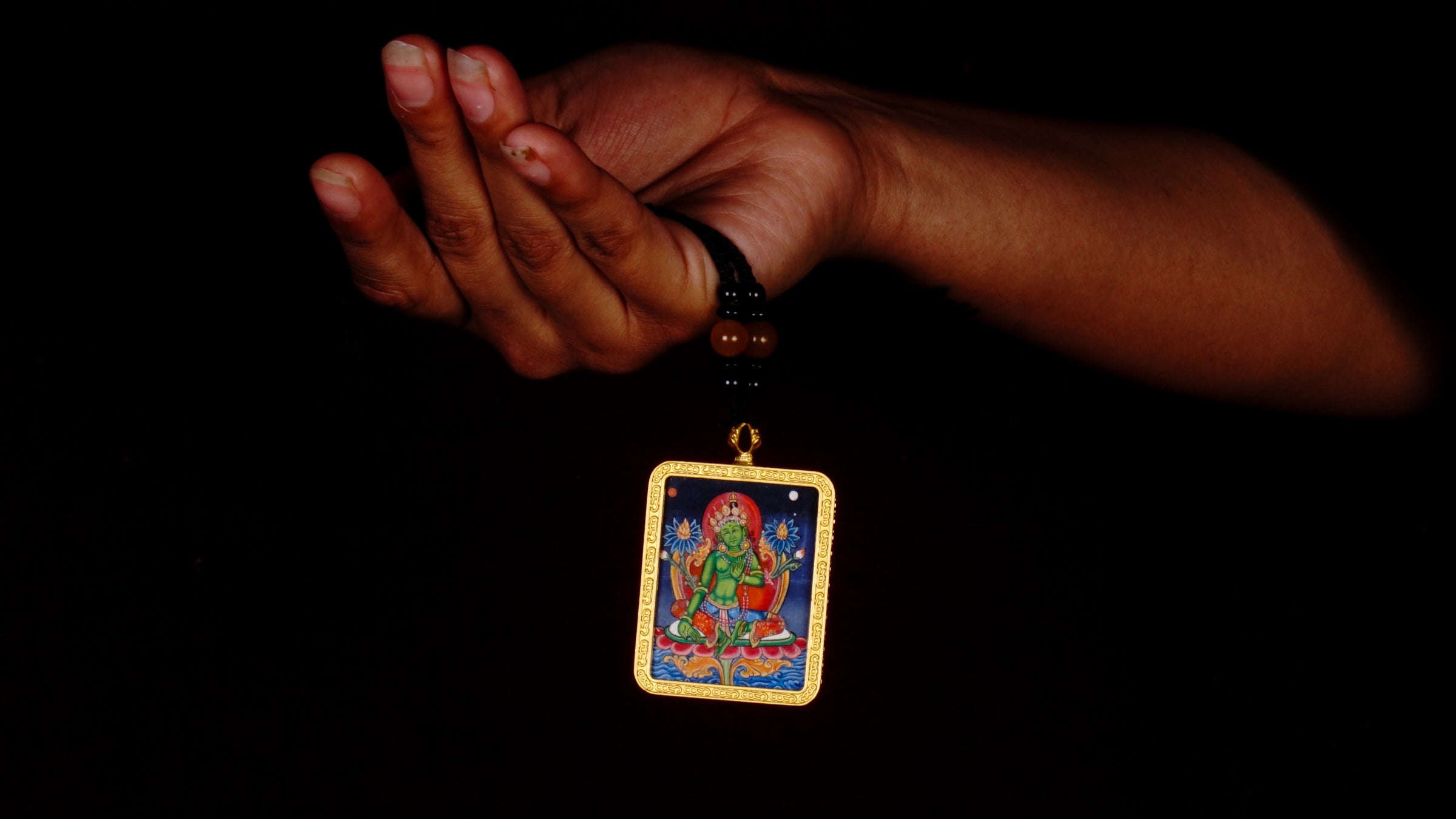 Hand-painted Green Tara miniature Thangka pendant in gold-accented copper Ghau locket with black beaded cord.