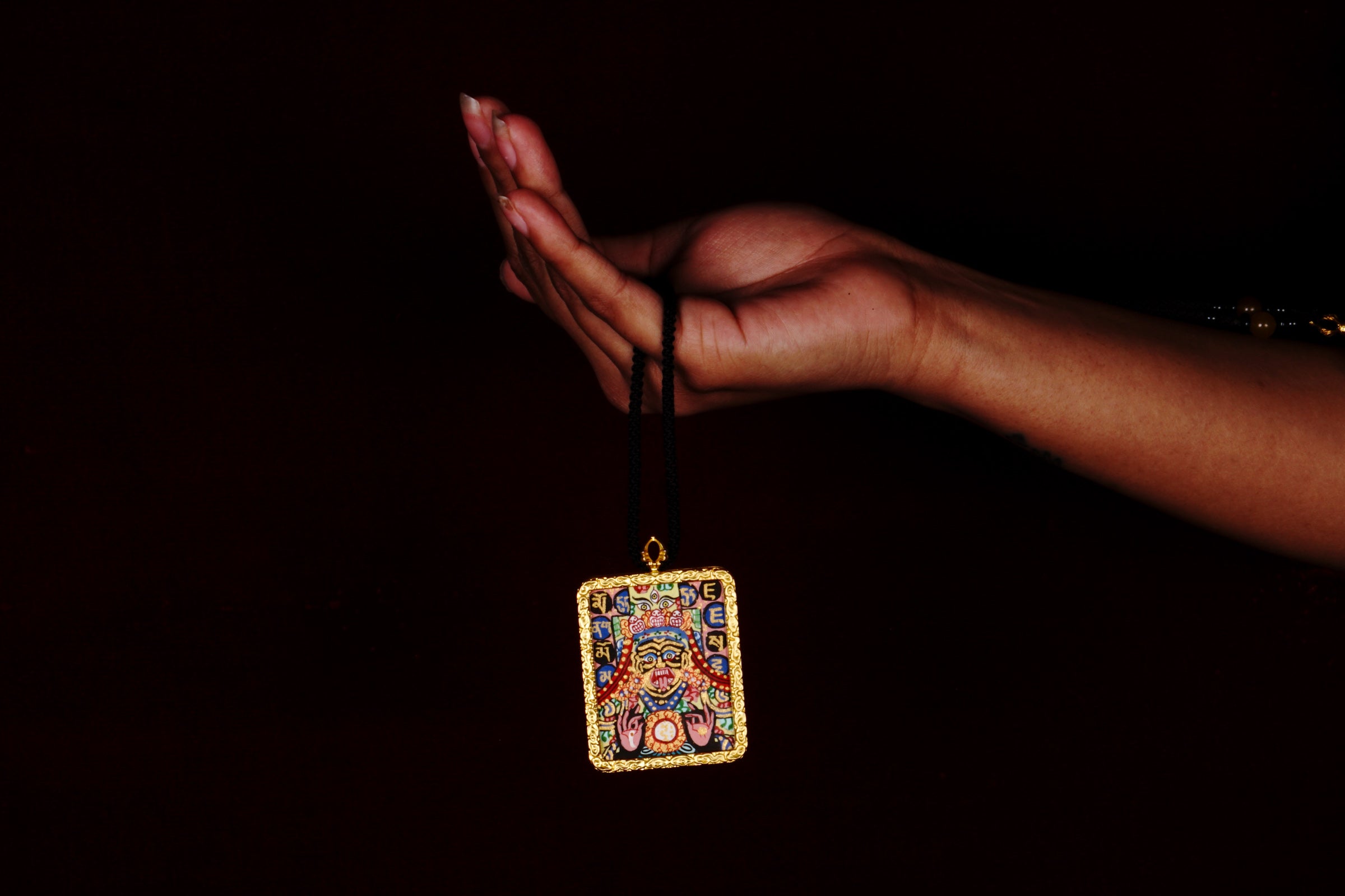Hand-painted Goddess Kali miniature Thangka pendant in gold-accented copper Ghau locket with black cord.