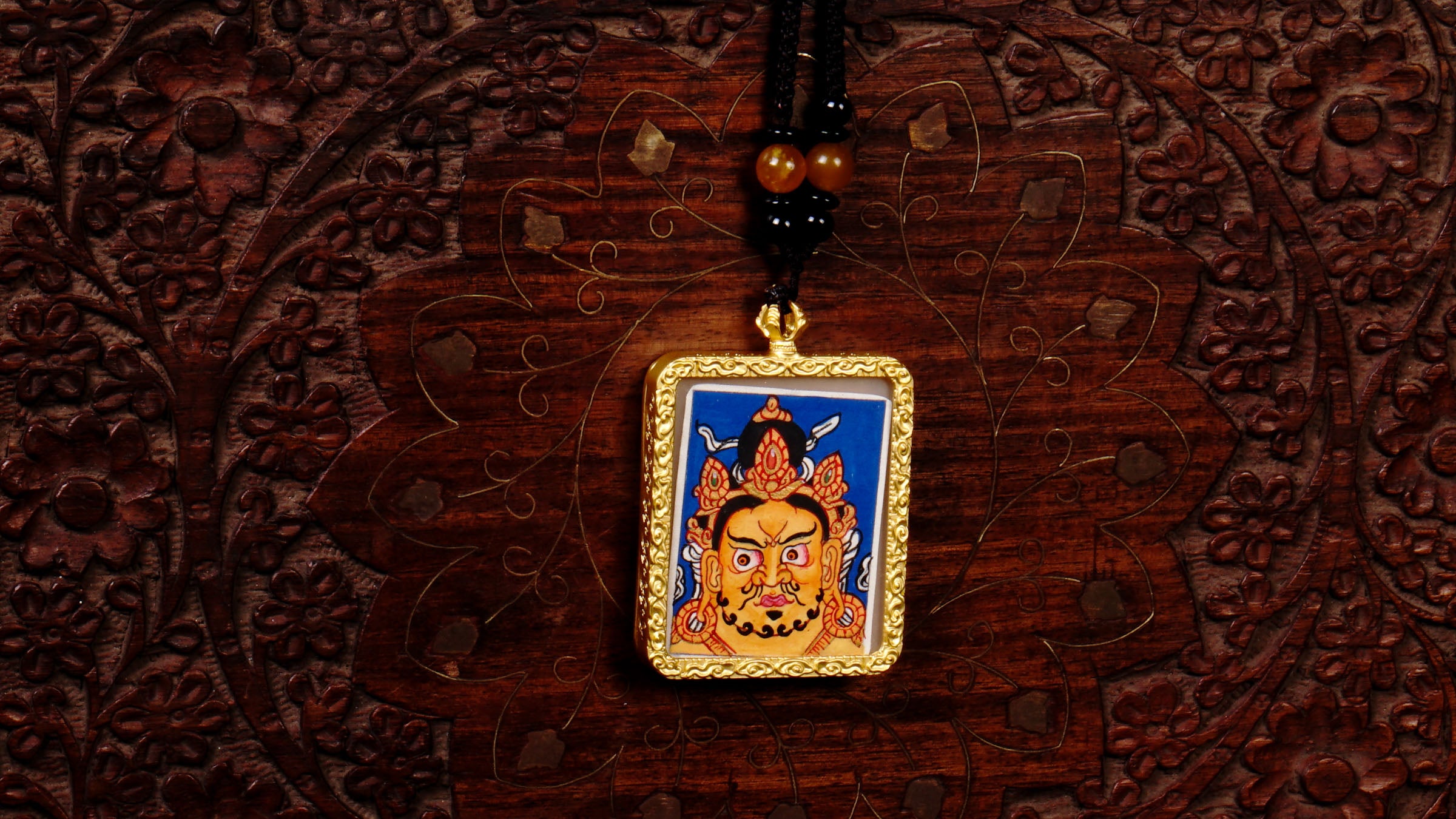Hand-painted Zambala wealth deity miniature Thangka pendant in gold-accented copper Ghau locket with black beaded cord.