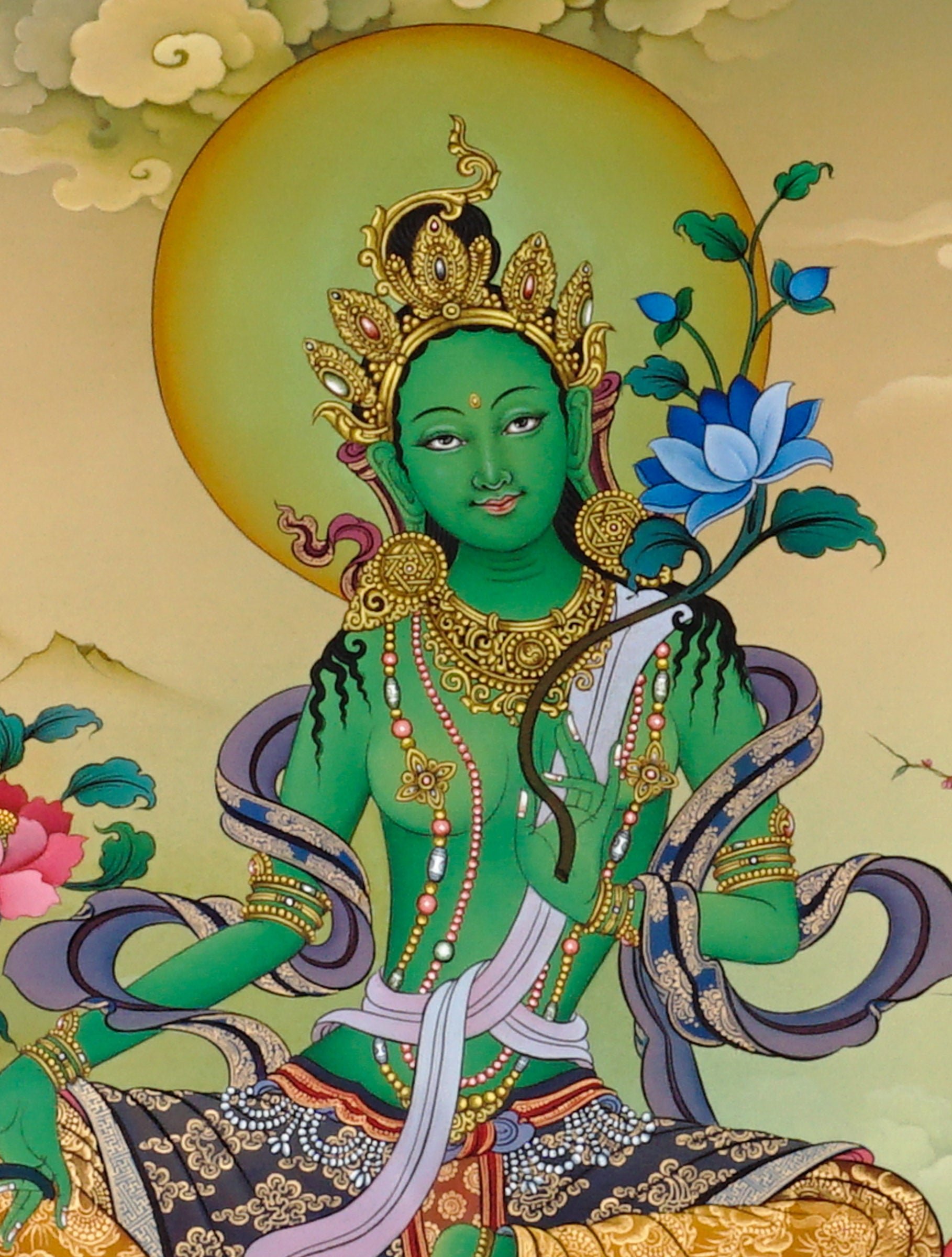 Hand-painted Green Tara thangka showing Tibetan Buddhist goddess seated on lotus throne holding blue utpala lotus, with Amitabha above and Himalayan landscape background.