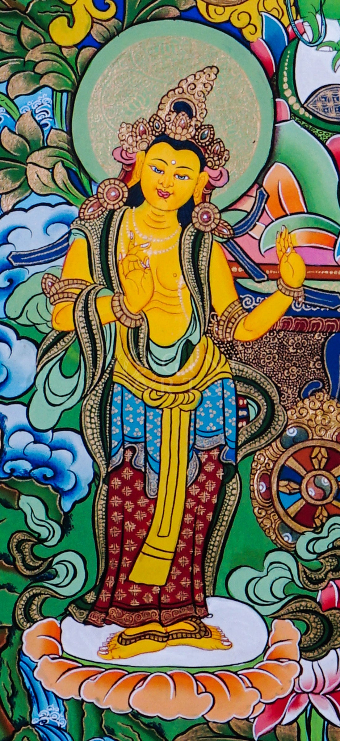 Green Tara seated on a lotus throne surrounded by sacred floral motifs and traditional Himalayan Buddhist ornamentation.