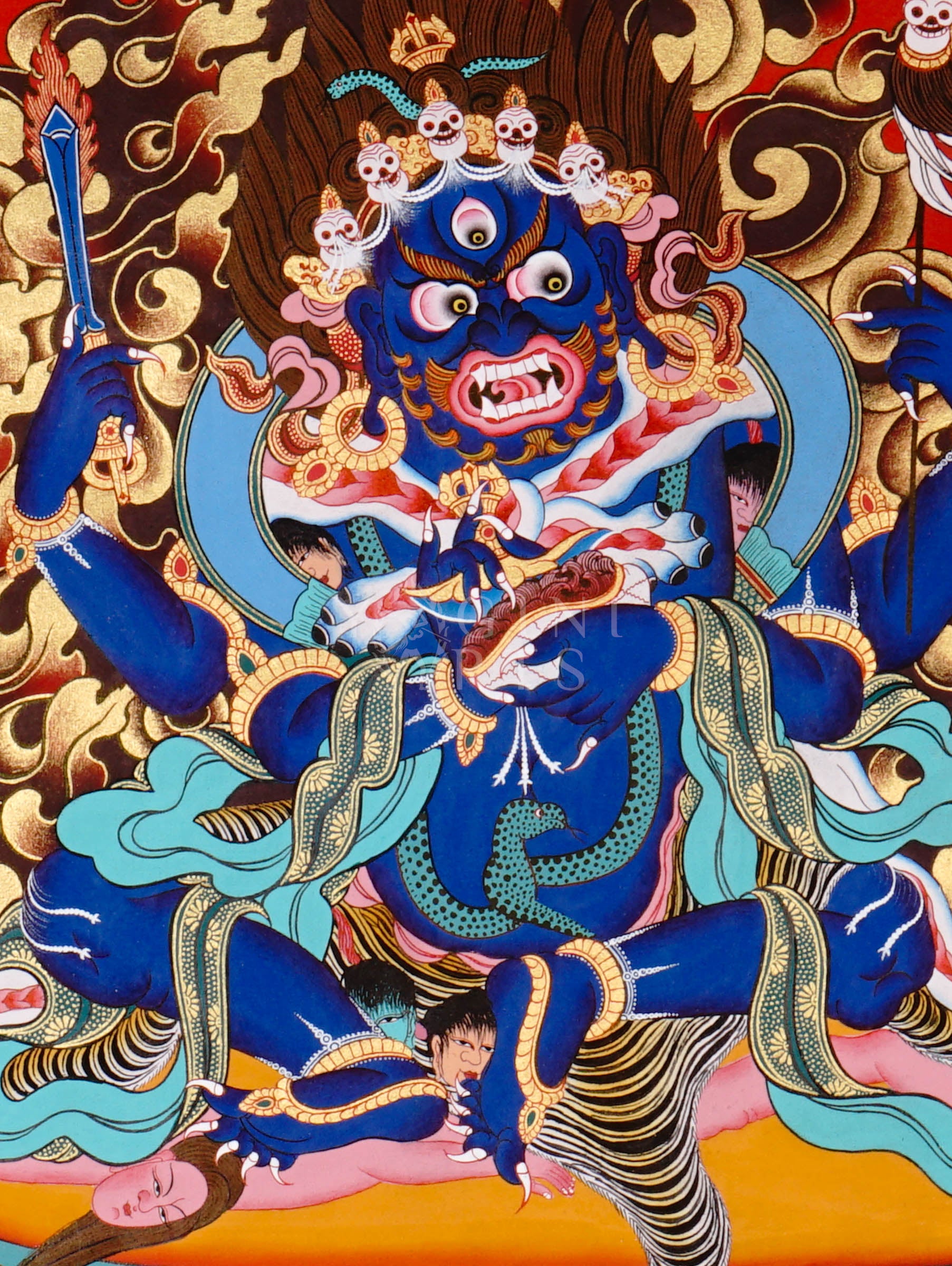Mahakala thangka showing a fierce blue wrathful deity with multiple arms, surrounded by flames and standing on subdued figures in traditional Tibetan style.