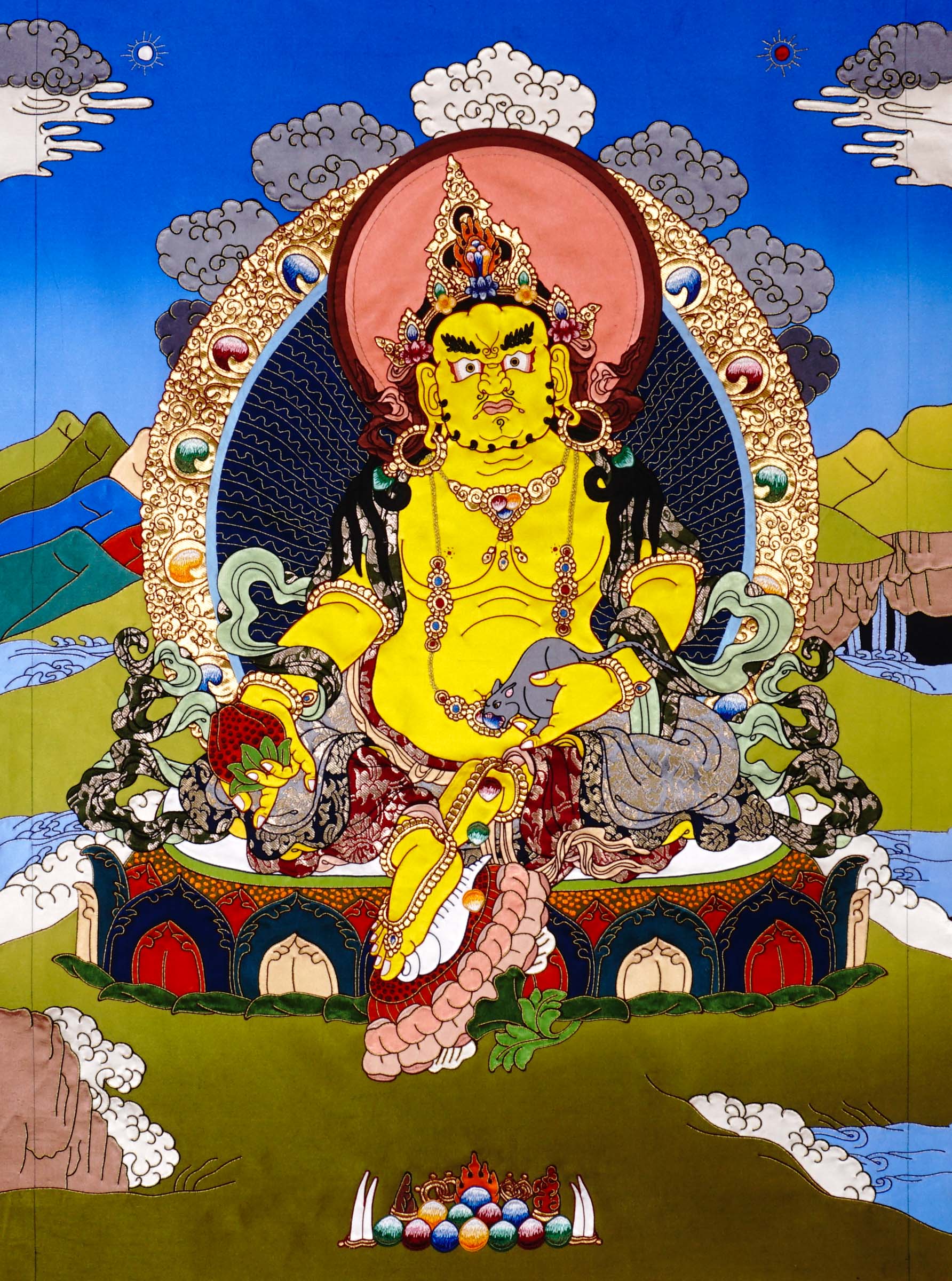 Yellow Dzambhala cloth thangka printed on fabric showing Tibetan wealth deity seated on lotus throne holding mongoose and citron with vibrant landscape background.