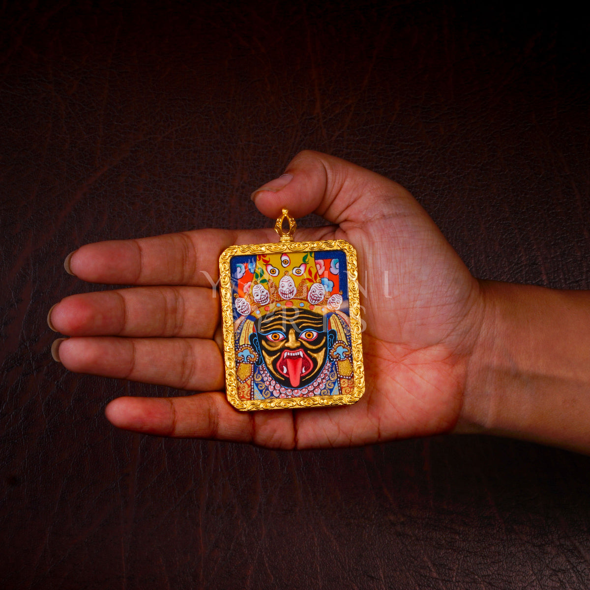 Hand-painted Zhaji Lhamo Ghau pendant in a gold-tone frame, handcrafted in Nepal using traditional Tibetan miniature painting techniques.