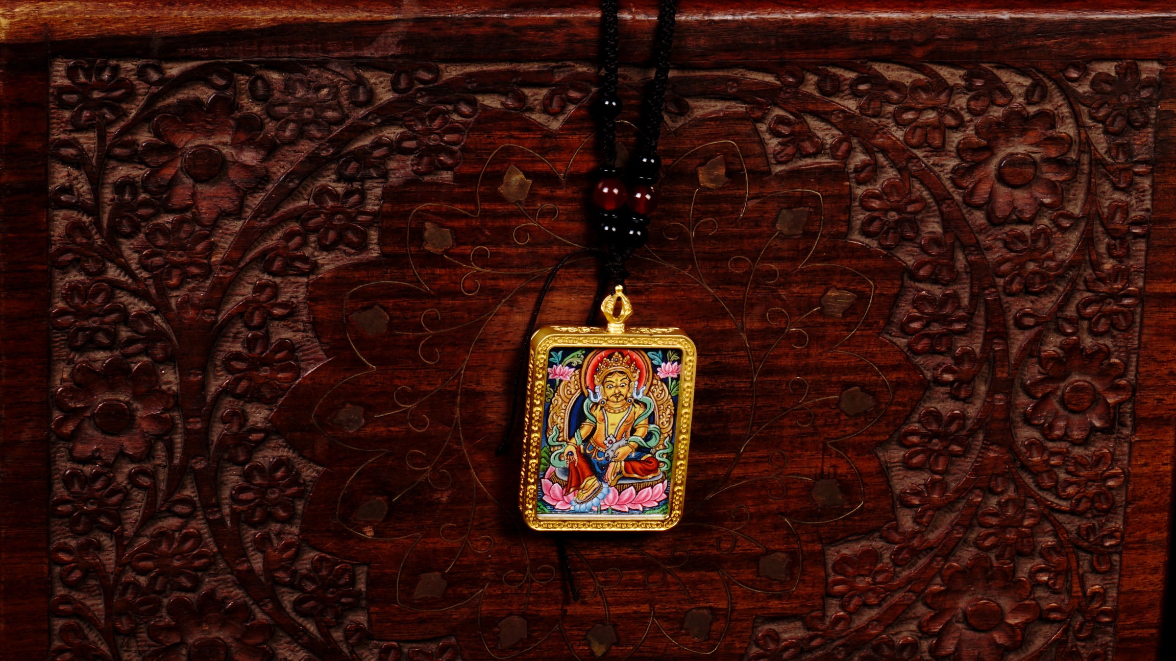 Hand-painted Yellow Zambala miniature Thangka pendant in gold-accented copper Ghau locket with black beaded cord.