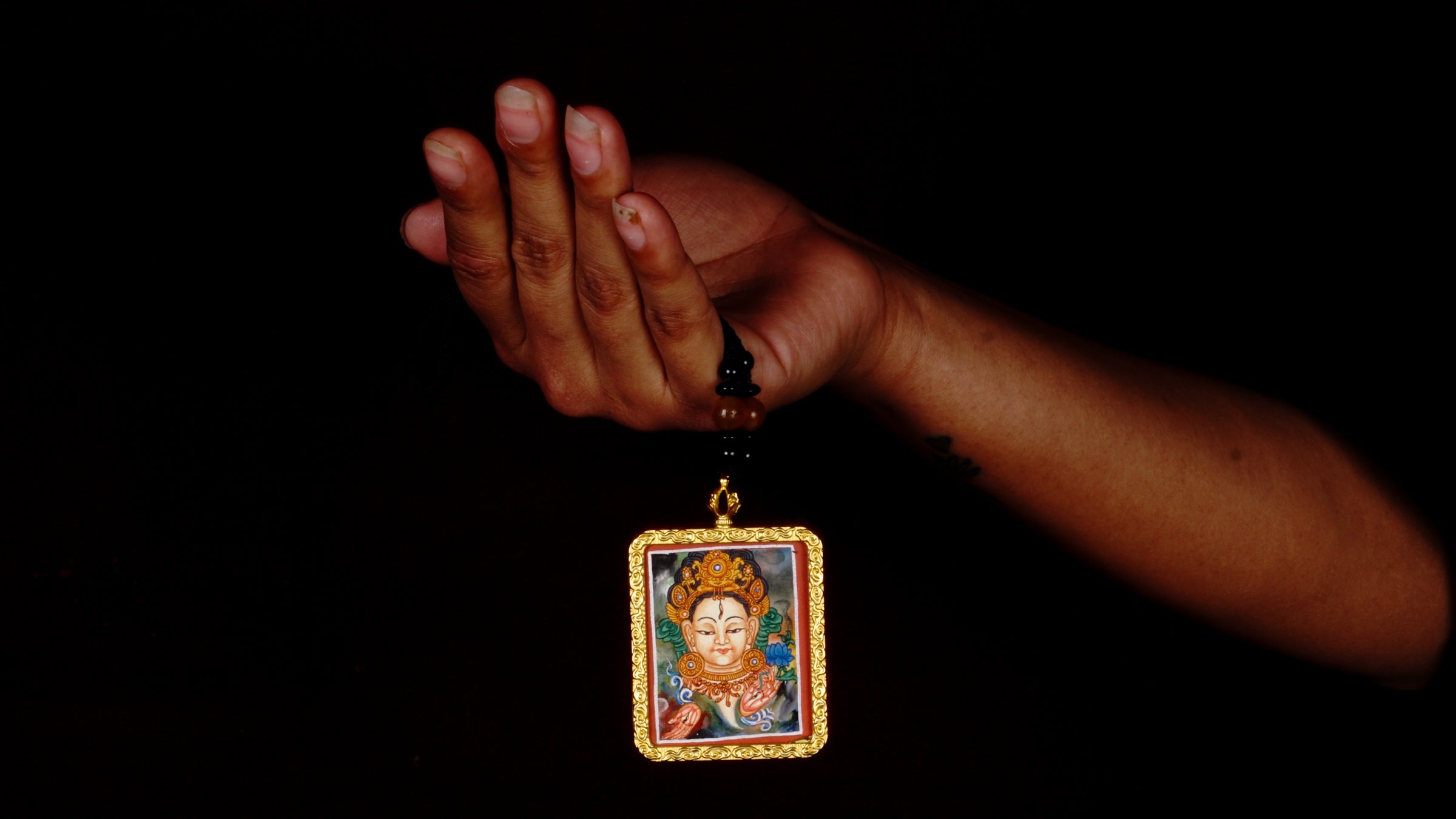Hand-painted White Tara miniature Thangka pendant in gold-accented copper Ghau locket with black beaded cord.