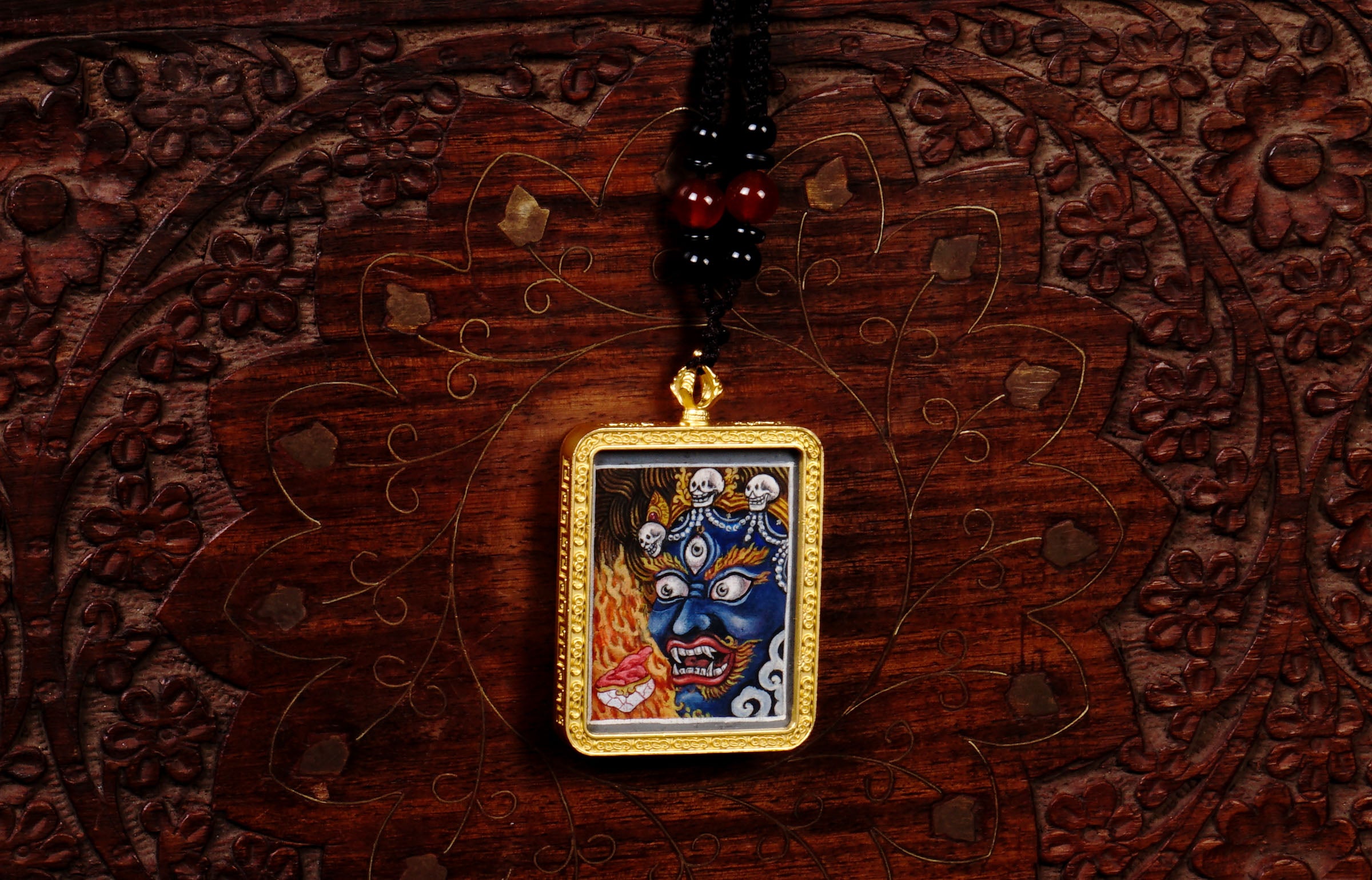 Hand-painted Mahakala miniature Thangka pendant in gold-accented copper Ghau locket with black beaded cord.
