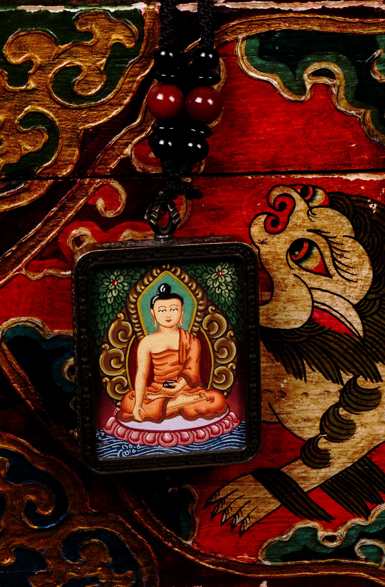 Hand-painted Shakyamuni Buddha miniature Thangka pendant in gold-accented copper Ghau locket with black beaded cord.