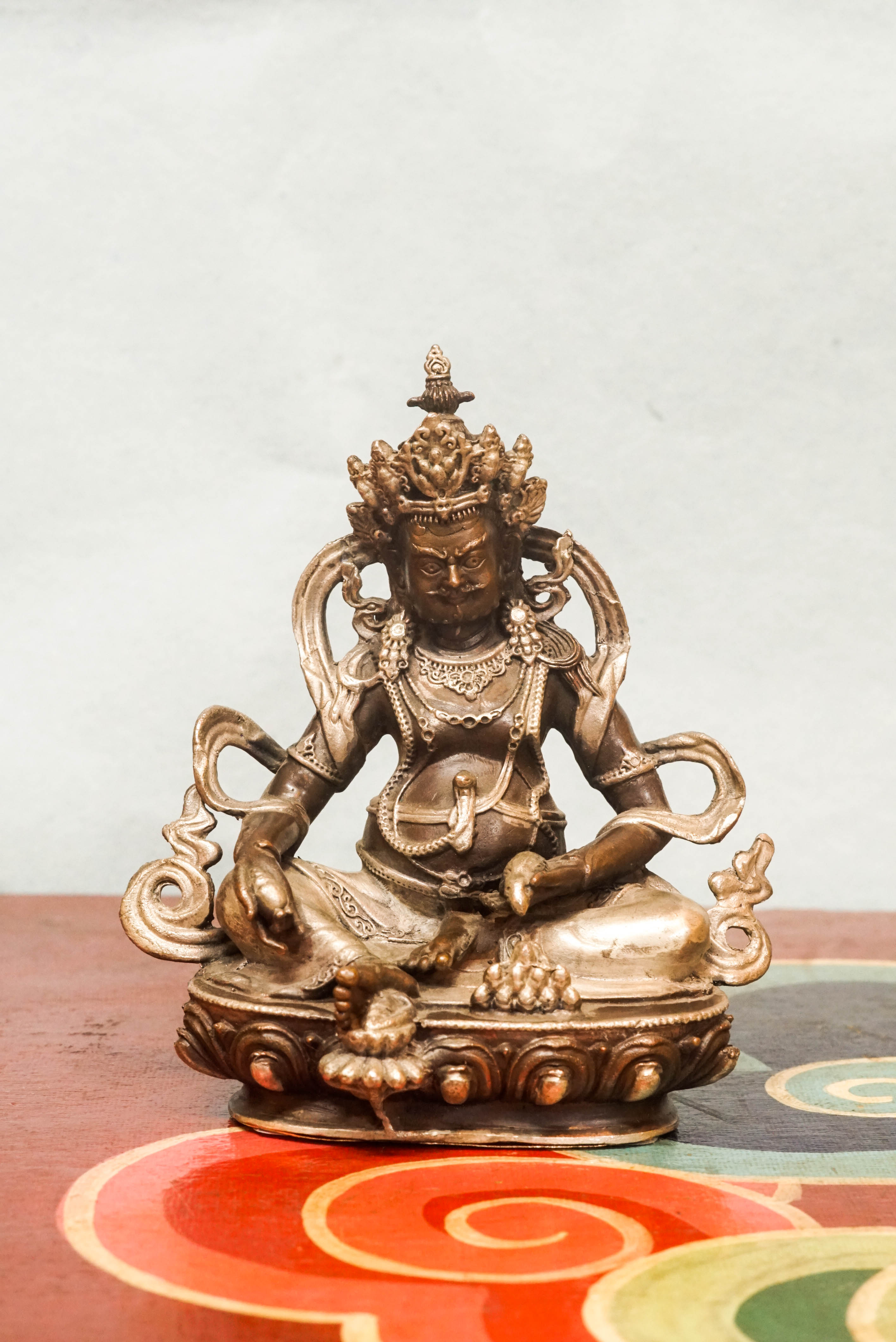Zambala statue adorned with crown and jewelry, symbolizing spiritual protection and material abundance.