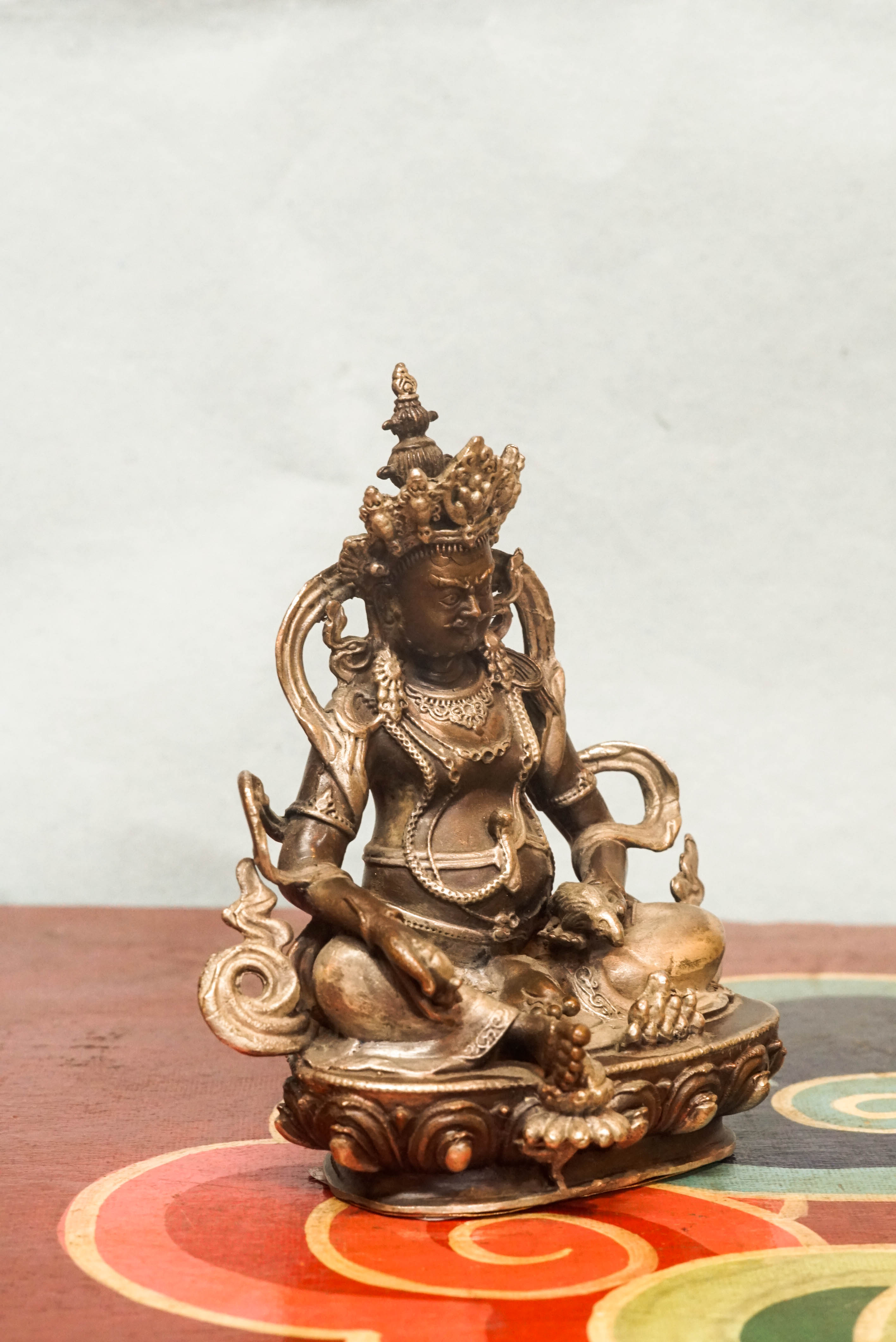 Zambala statue adorned with crown and jewelry, symbolizing spiritual protection and material abundance.