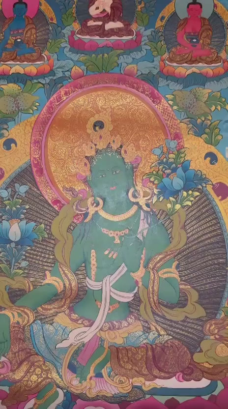 Green Tara thangka featuring the  Buddhist goddess of compassion seated on a lotus throne surrounded by vibrant sacred symbolism and gold detailing