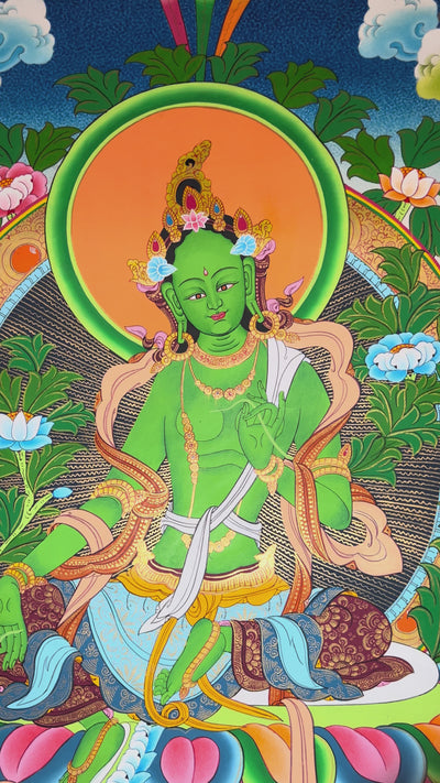 Green Tara thangka featuring the Tibetan Buddhist goddess seated on a lotus throne surrounded by flowers and sacred Himalayan landscape