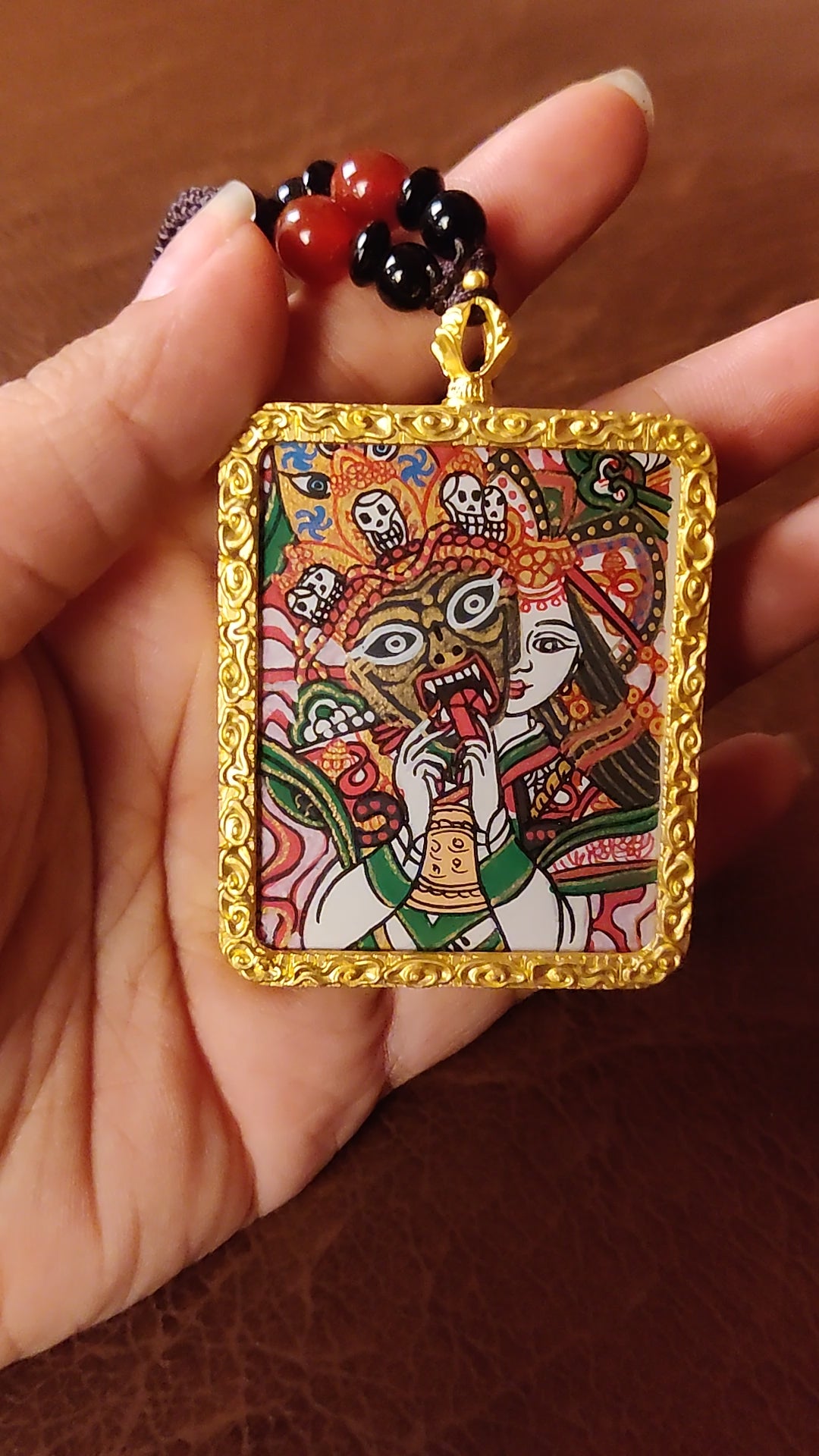 Hand-painted Zhaji Lhamo Ghau pendant in a gold-tone frame, handcrafted in Nepal using traditional Himalayan miniature painting techniques.