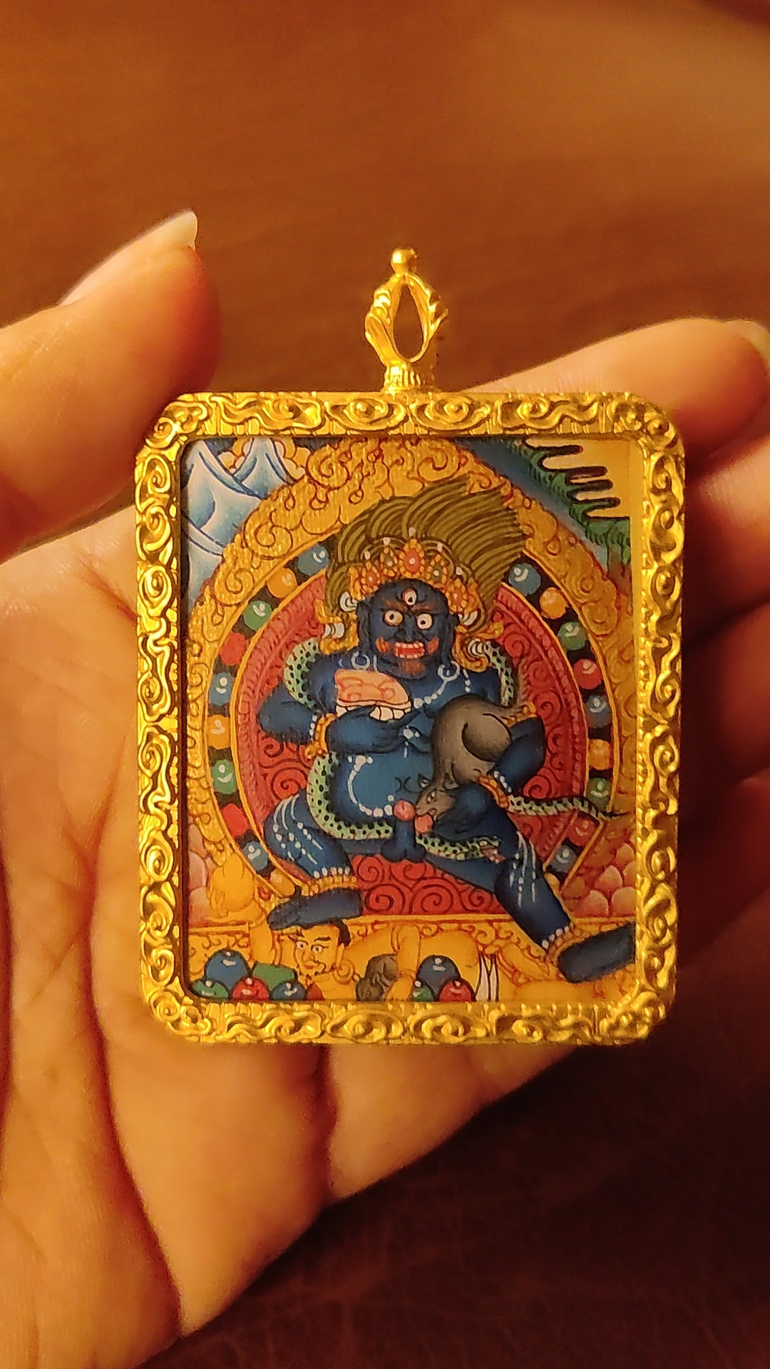 Hand-painted Black Zambhala Ghau pendant in a gold-tone frame, handcrafted in Nepal using traditional Tibetan miniature painting techniques.