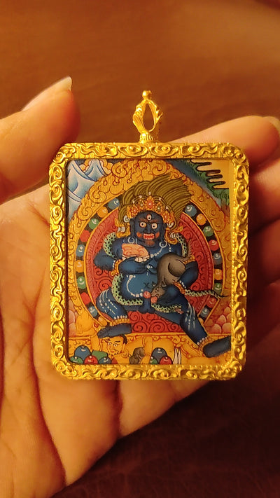 Hand-painted Black Zambhala Ghau pendant in a gold-tone frame, handcrafted in Nepal using traditional Tibetan miniature painting techniques.