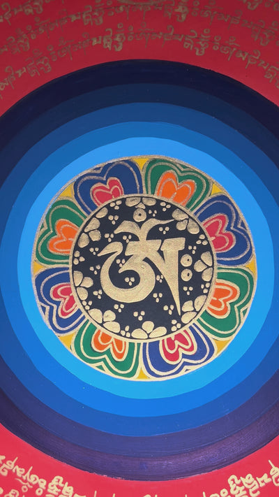 Tibetan mantra mandala thangka with black background, multicolor central rings, gold script circles, and floral corner designs.