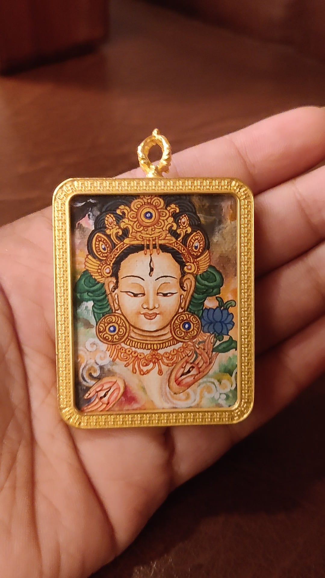 Newari White Tara Ghau pendant featuring a miniature Tibetan Buddhist goddess artwork in a decorative gold-tone frame handcrafted in Nepal.