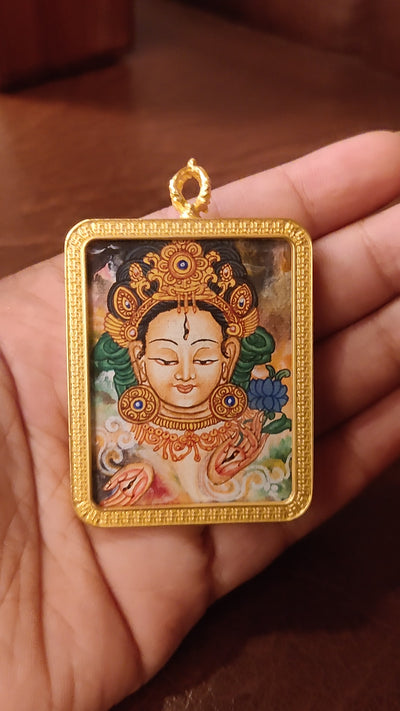 Newari White Tara Ghau pendant featuring a miniature Tibetan Buddhist goddess artwork in a decorative gold-tone frame handcrafted in Nepal.