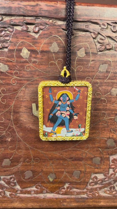 Hand-painted Goddess Kali miniature Thangka pendant in gold-accented copper Ghau locket with black beaded cord.