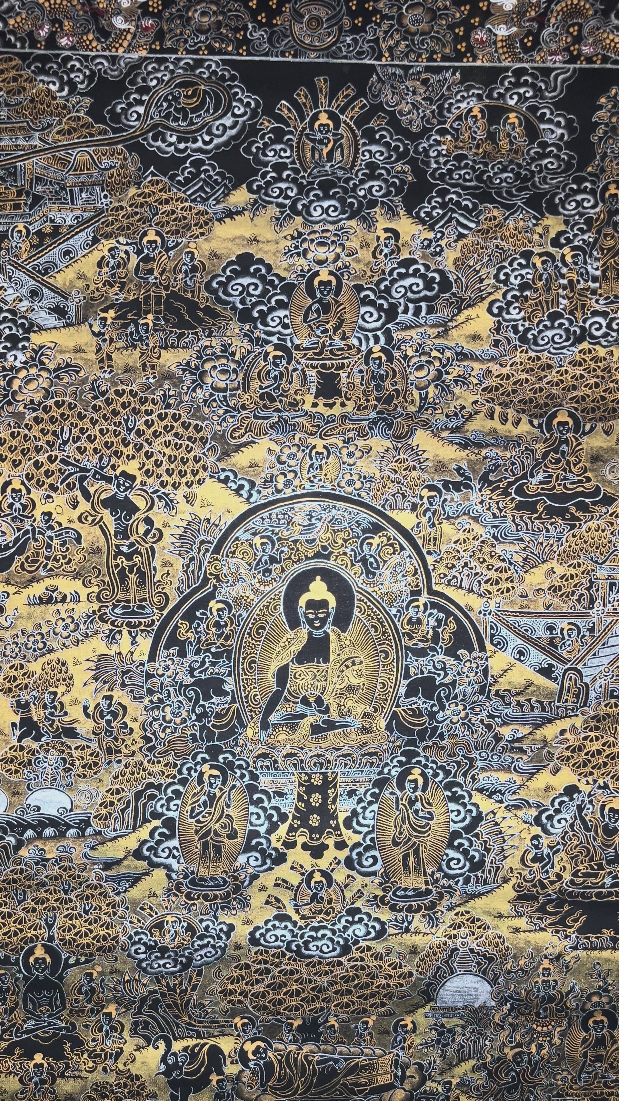 Hand-painted black and gold Tibetan Life of Buddha thangka featuring sacred narrative scenes surrounding the central Buddha figure with intricate Himalayan Buddhist detailing