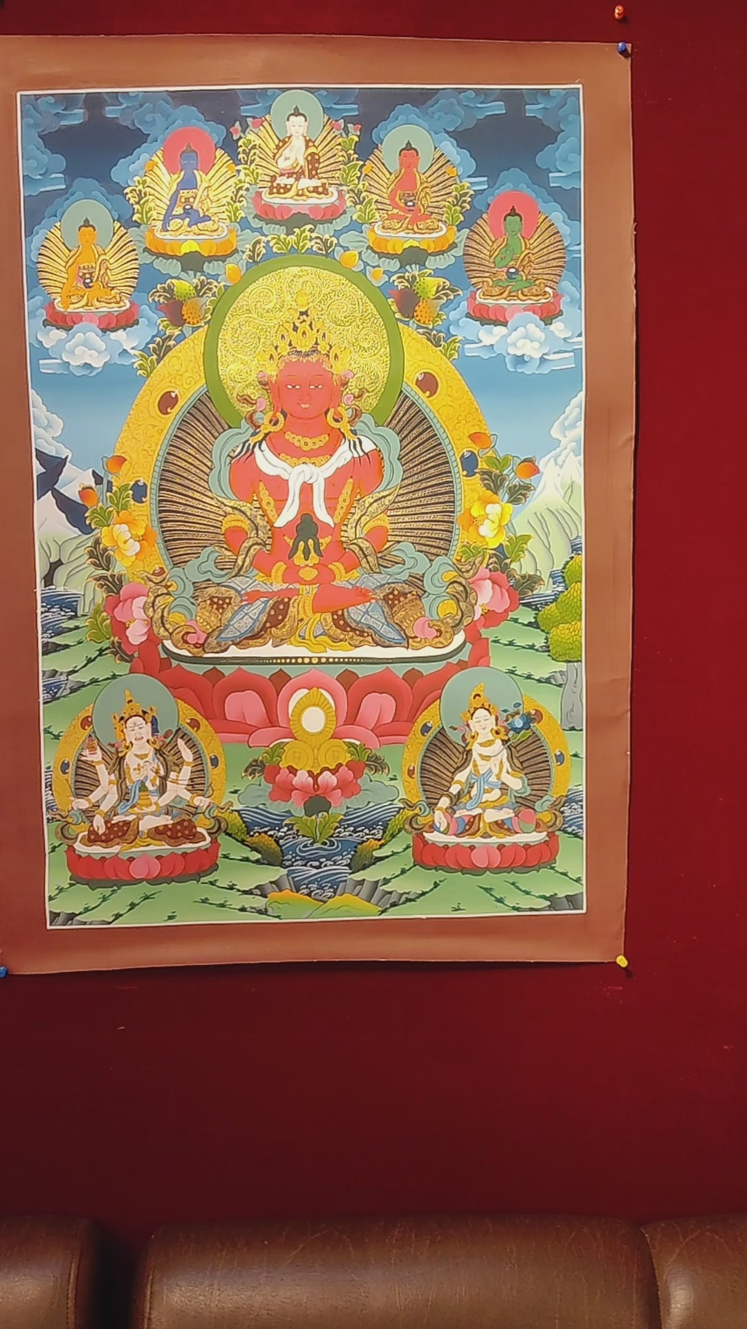 Amitayus thangka depicting the red Buddha of longevity seated on a lotus holding a vase, surrounded by Buddhas and floral landscape.