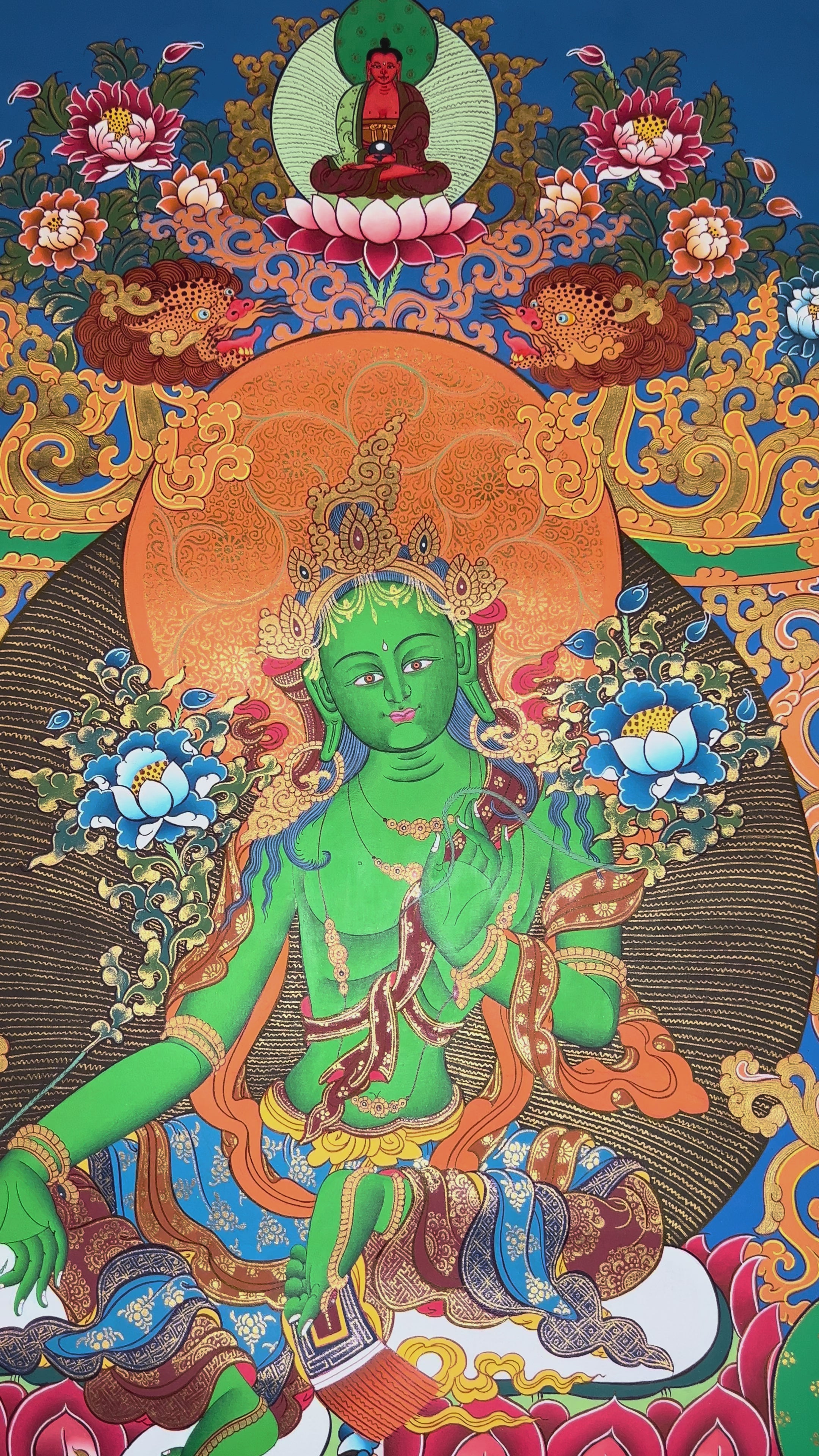Hand-painted Green Tara thangka featuring the Tibetan Buddhist goddess seated on a lotus throne surrounded by sacred floral motifs and celestial symbolism