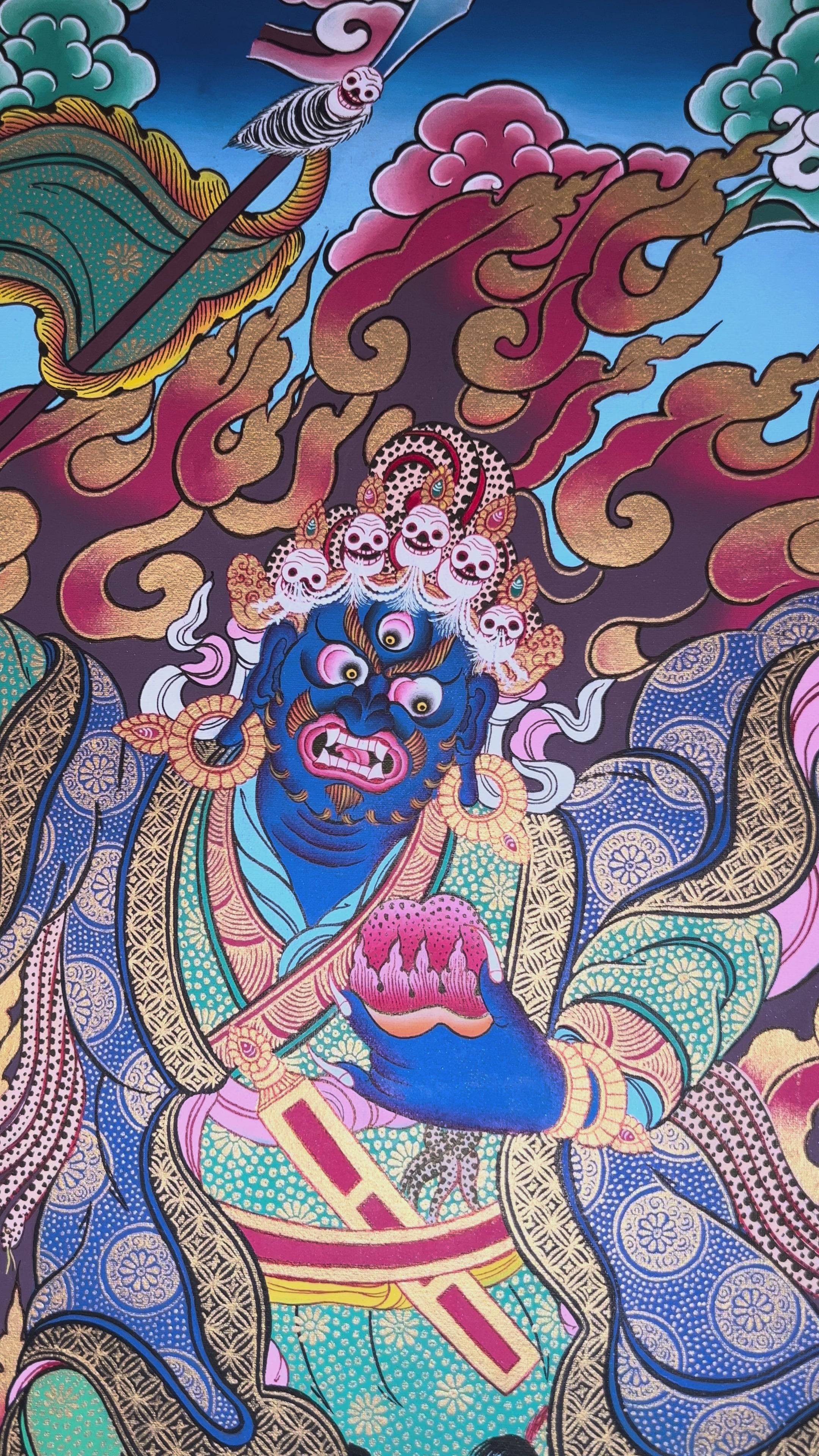 Khadga Pani thangka featuring a wrathful blue deity holding a sword, surrounded by flames and standing on subdued figures in traditional Tibetan style.