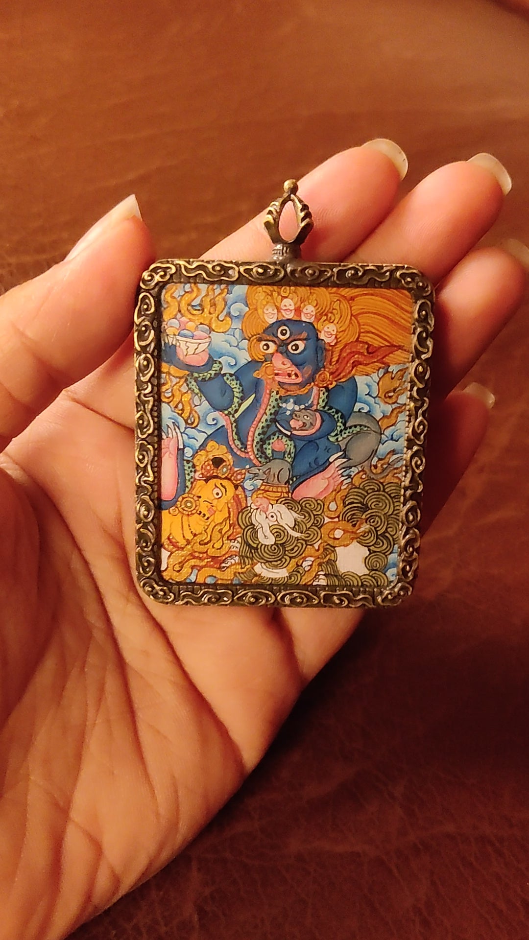 Hand-painted Black Zambhala Ghau pendant in an antique-style metal frame, handcrafted in Nepal using traditional Tibetan miniature painting techniques.
