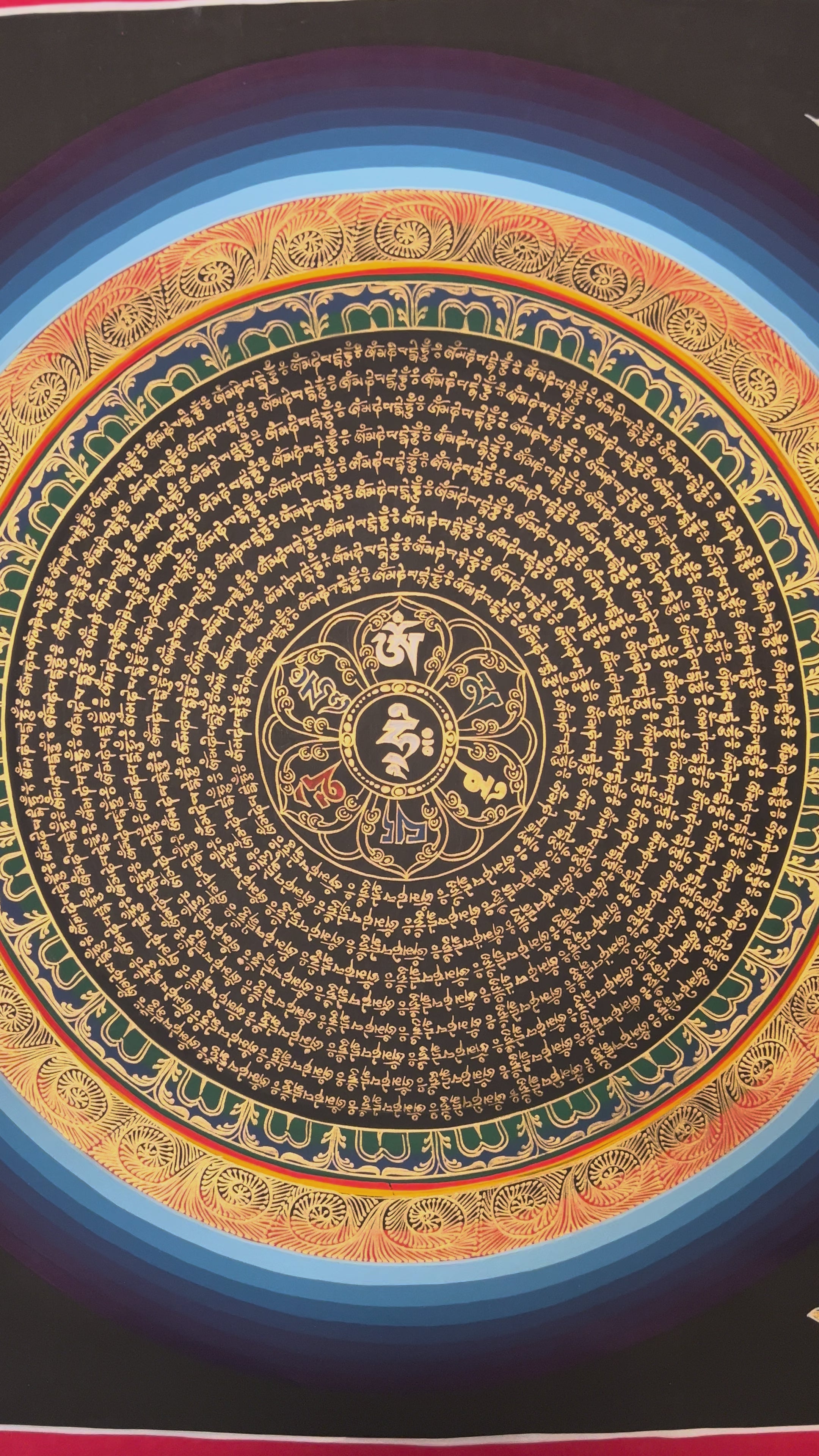 Golden Tibetan mantra mandala with Om symbol on black background.
