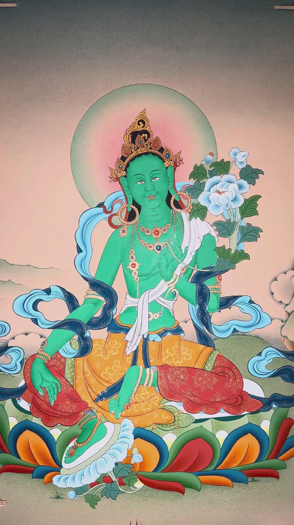 Hand-painted Green Tara thangka featuring the Tibetan Buddhist goddess seated on a lotus throne holding a blue lotus flower in a peaceful Himalayan landscape