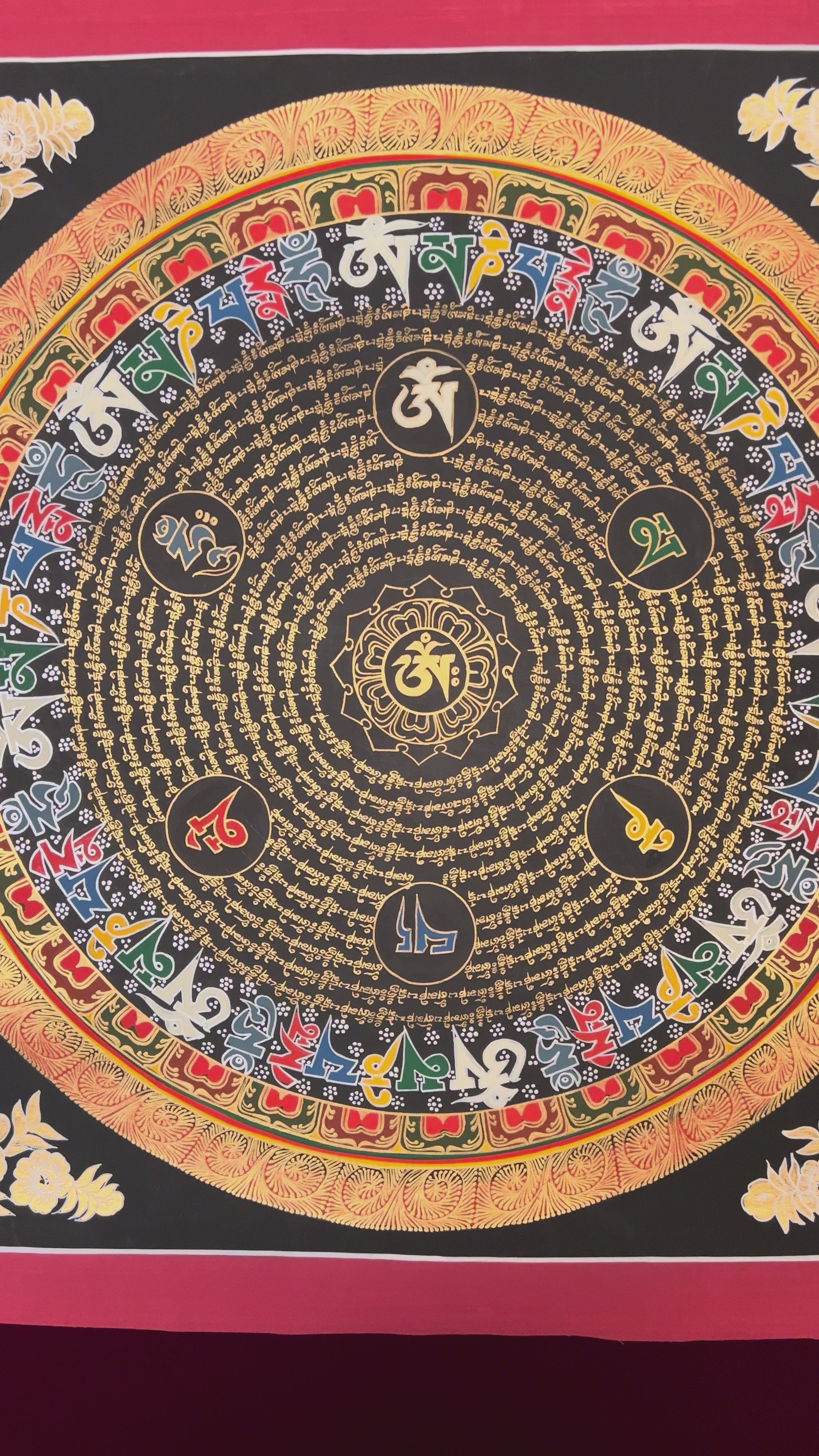 Multicolor Tibetan mantra mandala with five wisdom colors and gold script on black background.