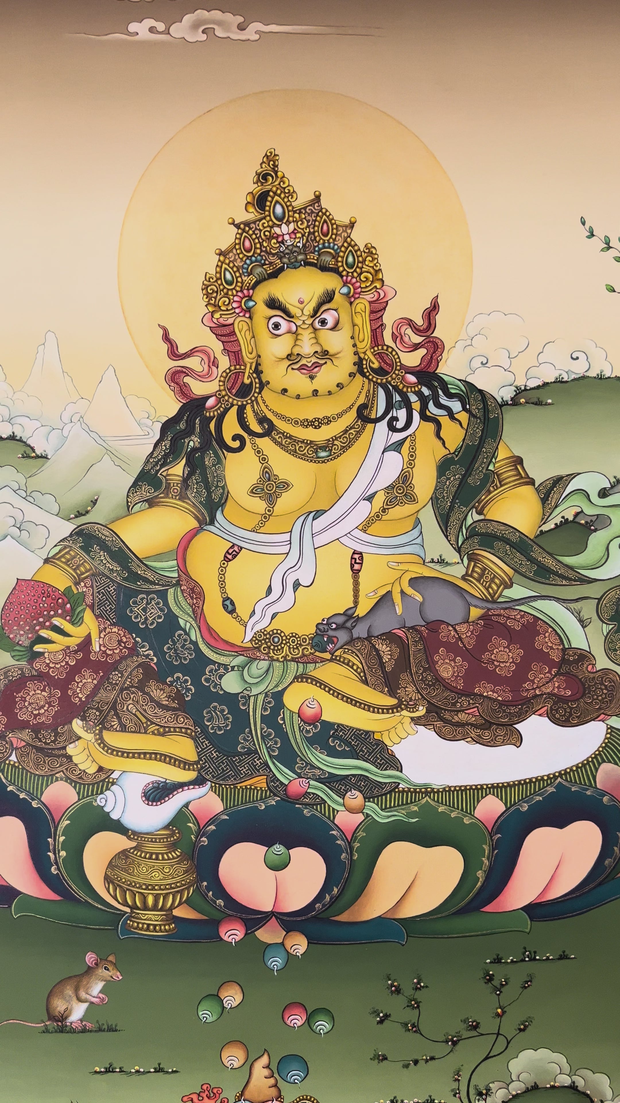 Hand-painted Yellow Dzambhala thangka showing Tibetan wealth deity seated on lotus throne holding mongoose and citron, with gold detailing and Himalayan landscape background.