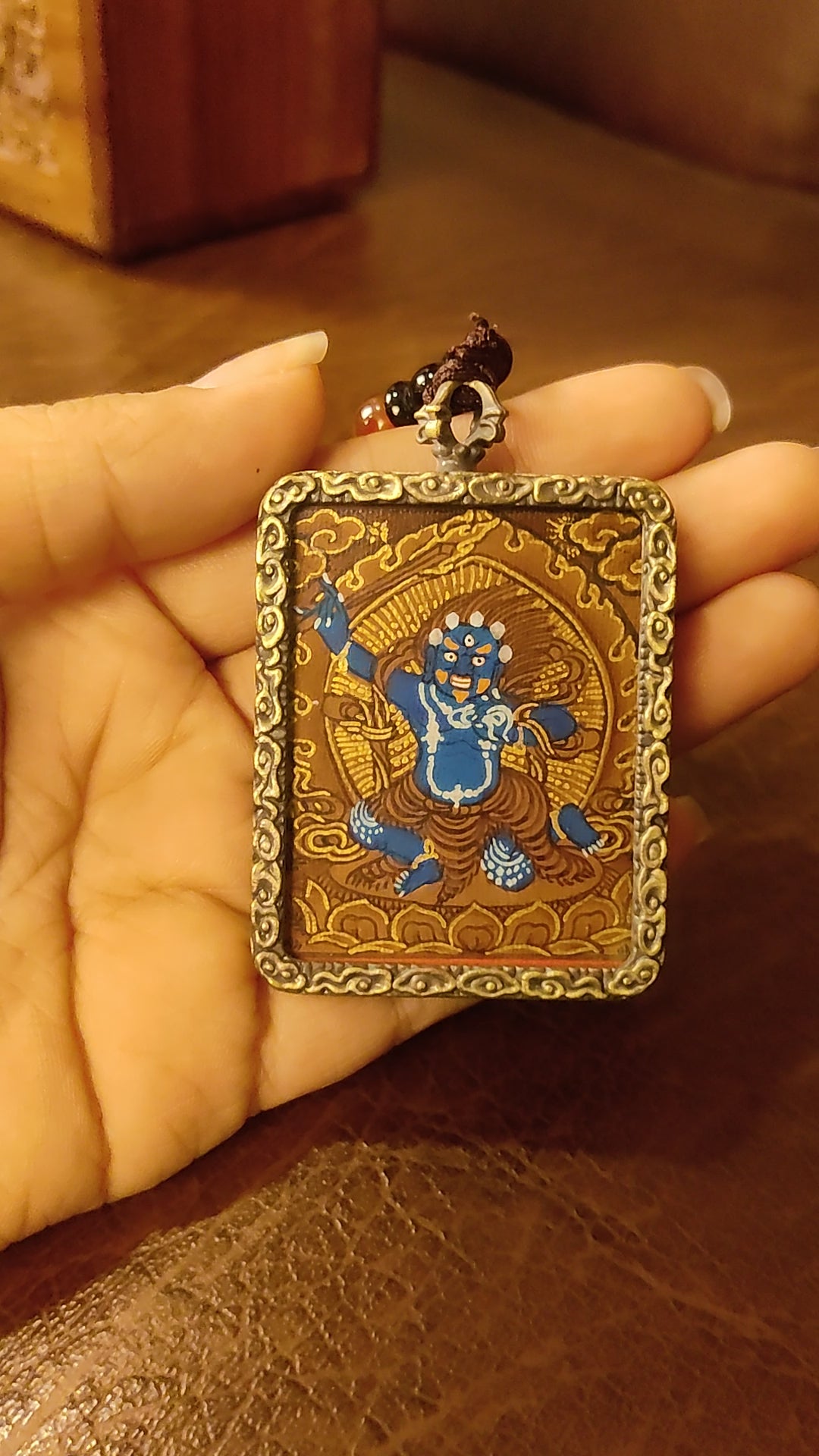 Khadgapani (Black Manjushree) Ghau pendant featuring a miniature Tibetan Buddhist wisdom protector artwork in a traditional metal frame handcrafted in Nepal.