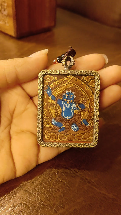 Khadgapani (Black Manjushree) Ghau pendant featuring a miniature Tibetan Buddhist wisdom protector artwork in a traditional metal frame handcrafted in Nepal.