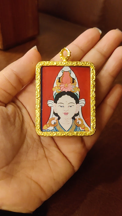 Hand-painted Chinese Tara Ghau pendant featuring a miniature portrait of Tara in an ornate gold-colored frame, handcrafted in Nepal.