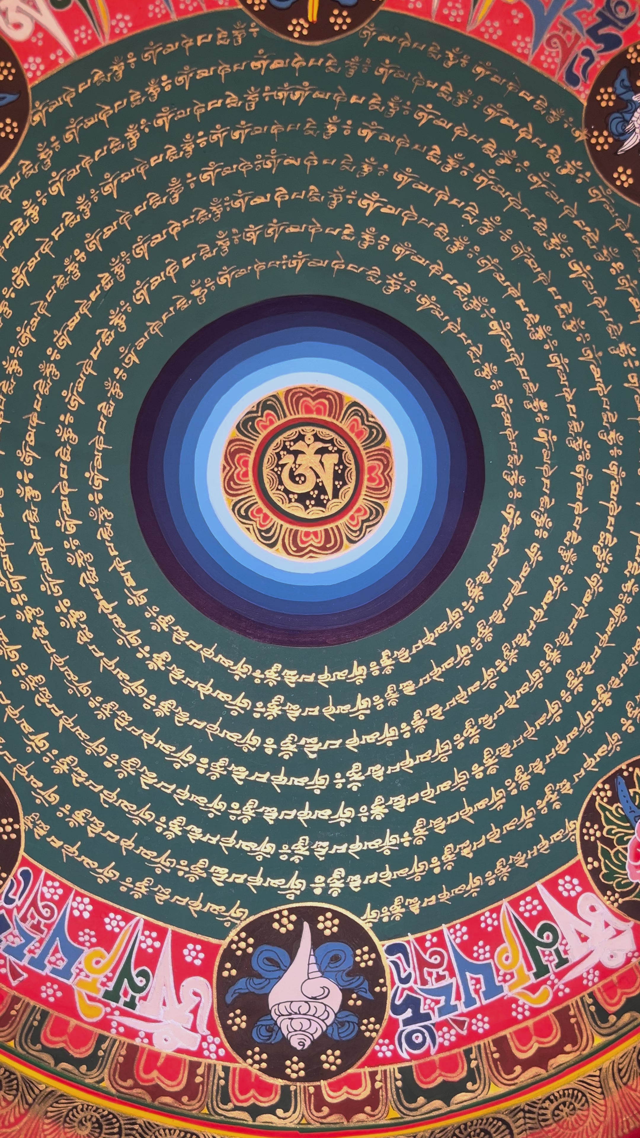 Tibetan mantra mandala thangka featuring concentric circles of sacred script with a central seed syllable surrounded by auspicious symbols on a red and gold background.