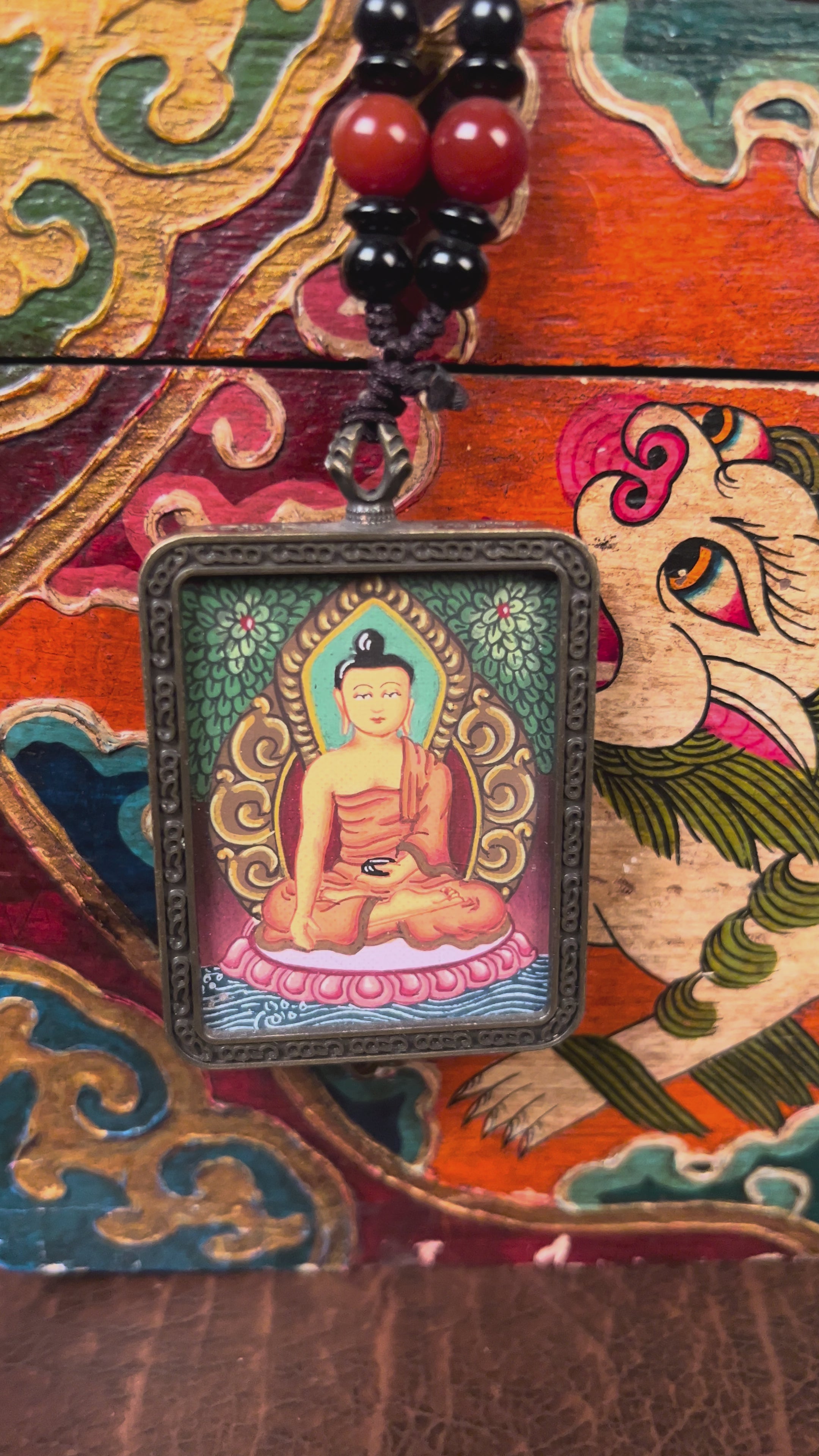 Hand-painted Shakyamuni Buddha miniature Thangka pendant in gold-accented copper Ghau locket with black beaded cord.
