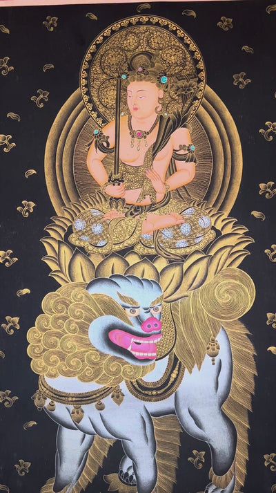 Hand-painted Manjushri thangka in gold on black canvas featuring the Buddhist wisdom deity seated on a snow lion holding a flaming sword and lotus scripture