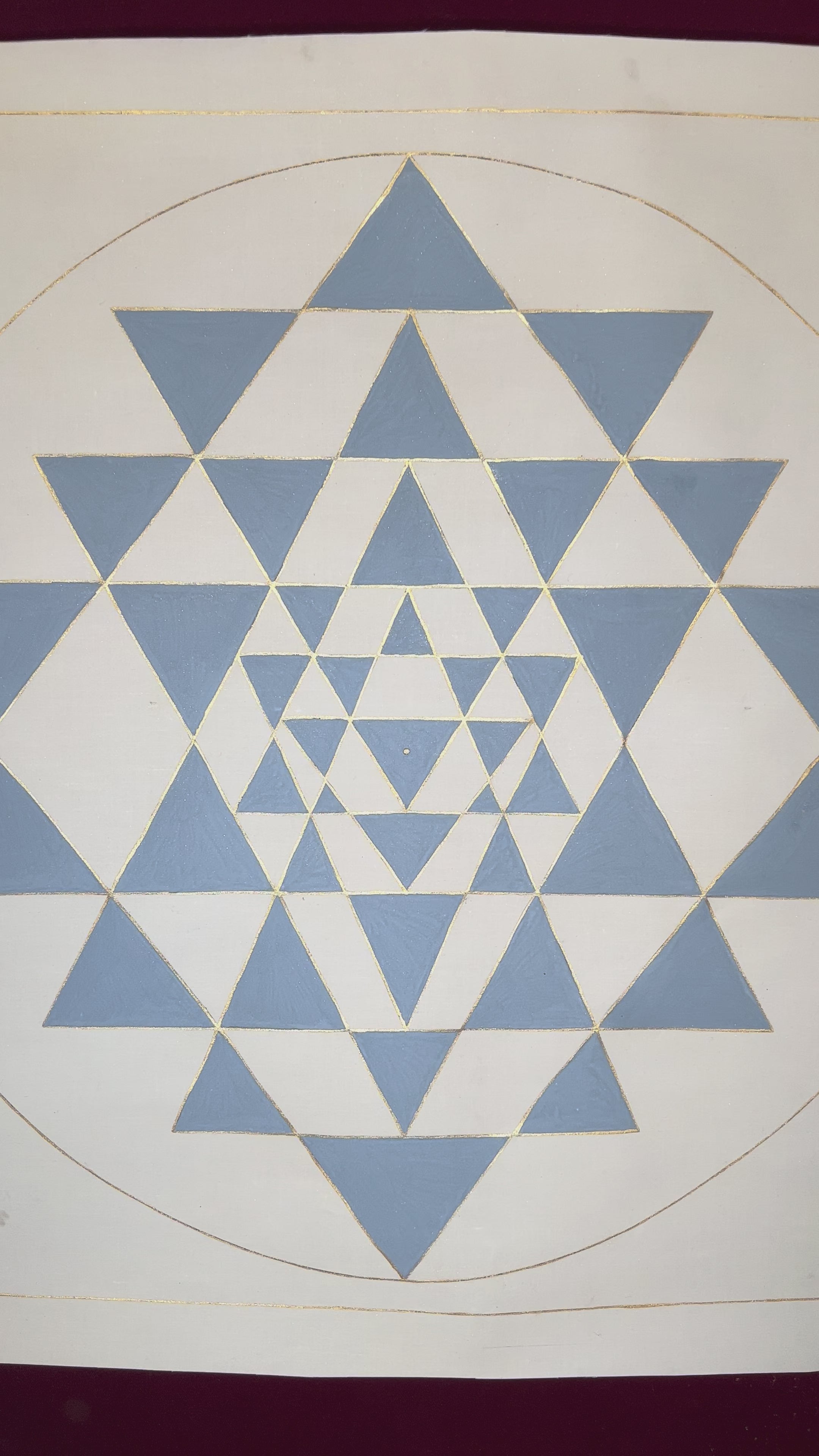 Shree Yantra sacred geometry artwork featuring interlocking blue triangles and gold outlines within a circular mandala