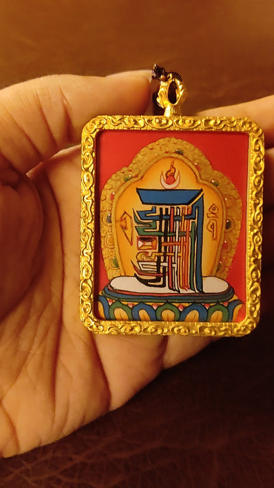 Hand-painted Kalachakra Mandala Ghau pendant in a gold-tone frame, handcrafted in Nepal using traditional Himalayan miniature painting techniques.