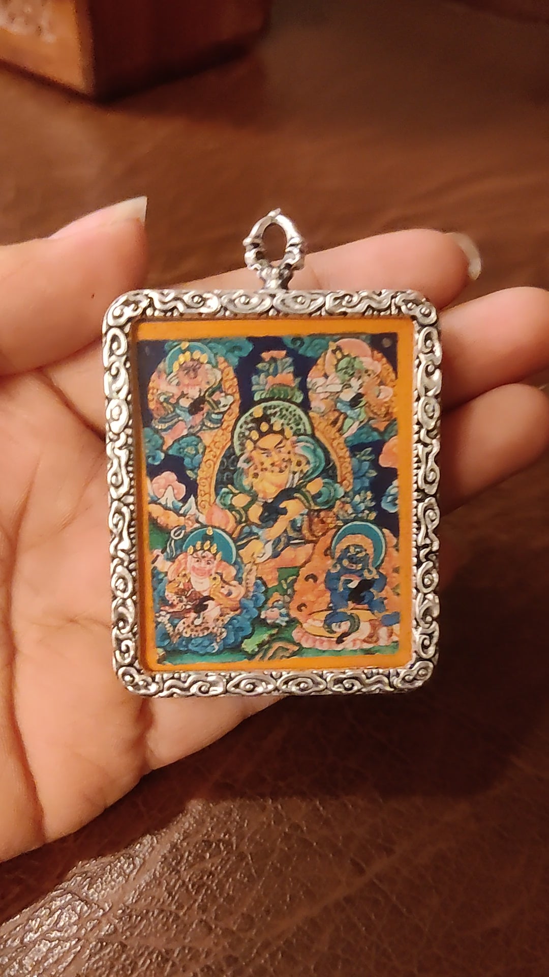Hand-painted Five Zambhala Ghau pendant featuring the Five Buddhist Wealth Deities in a handcrafted silver-tone frame made in Nepal.