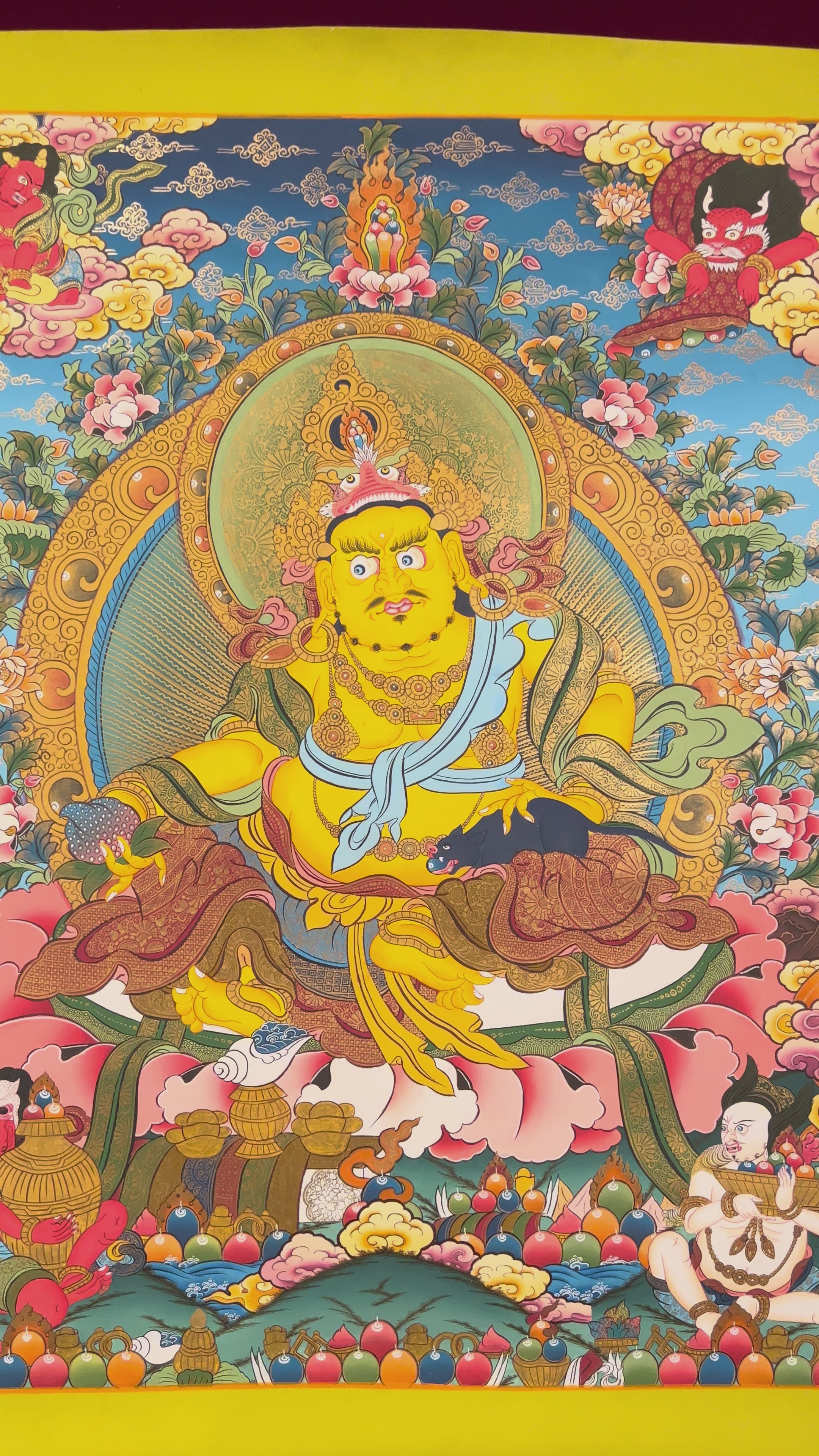 Hand-painted Yellow Zambhala thangka showing wealth deity with mongoose, fruit, and treasure offerings.